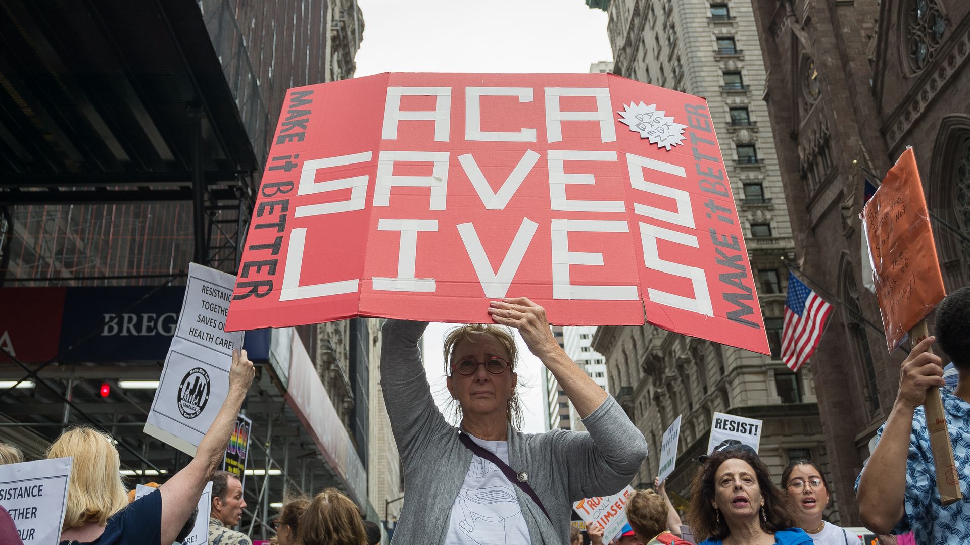 Protester holds sign saying "ACA Saves Lives"