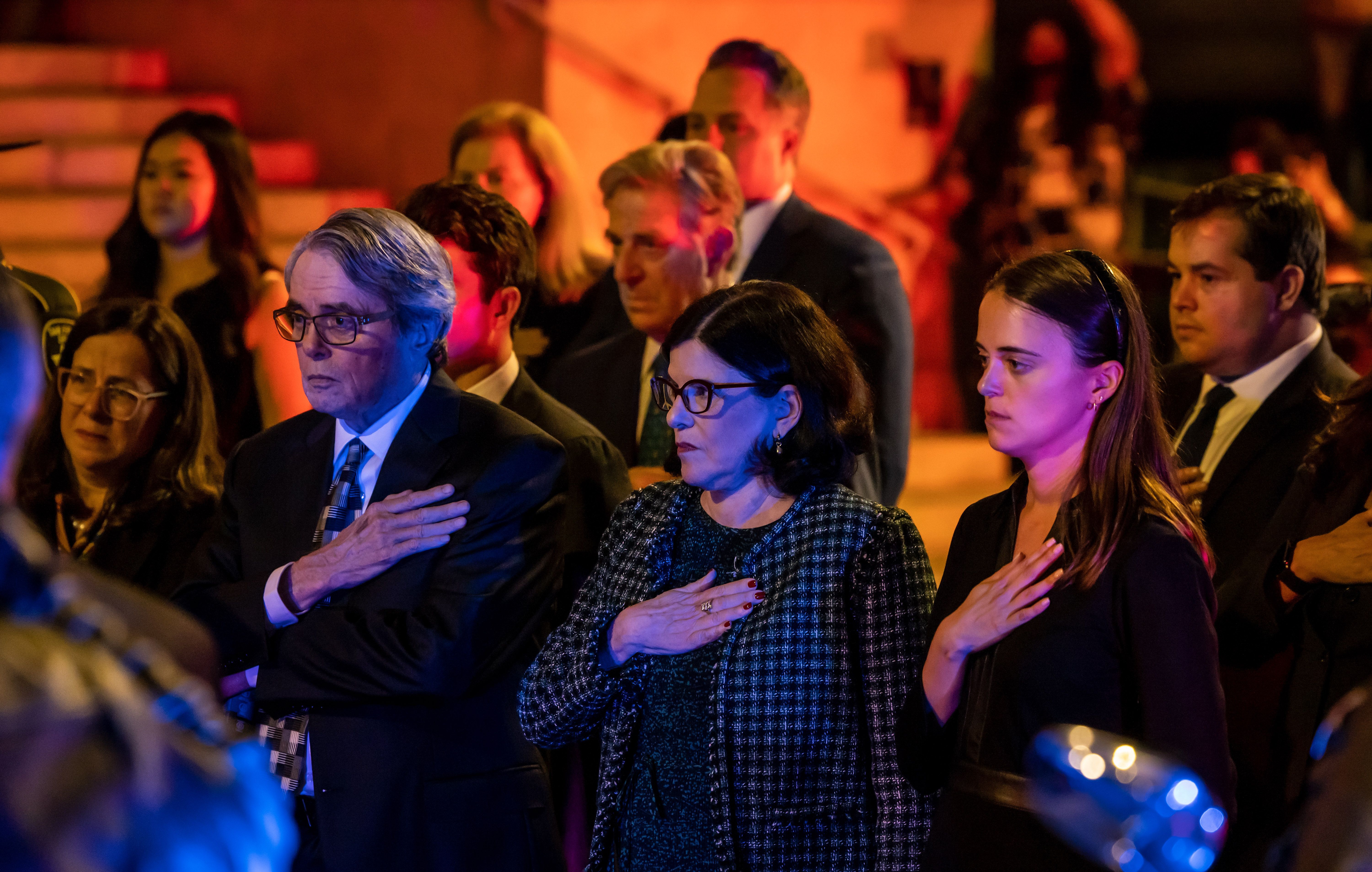 Feinstein's daughter, granddaughter and son in law have their hands over their hearts as Feinstein's casket is transported by the honor guard. 