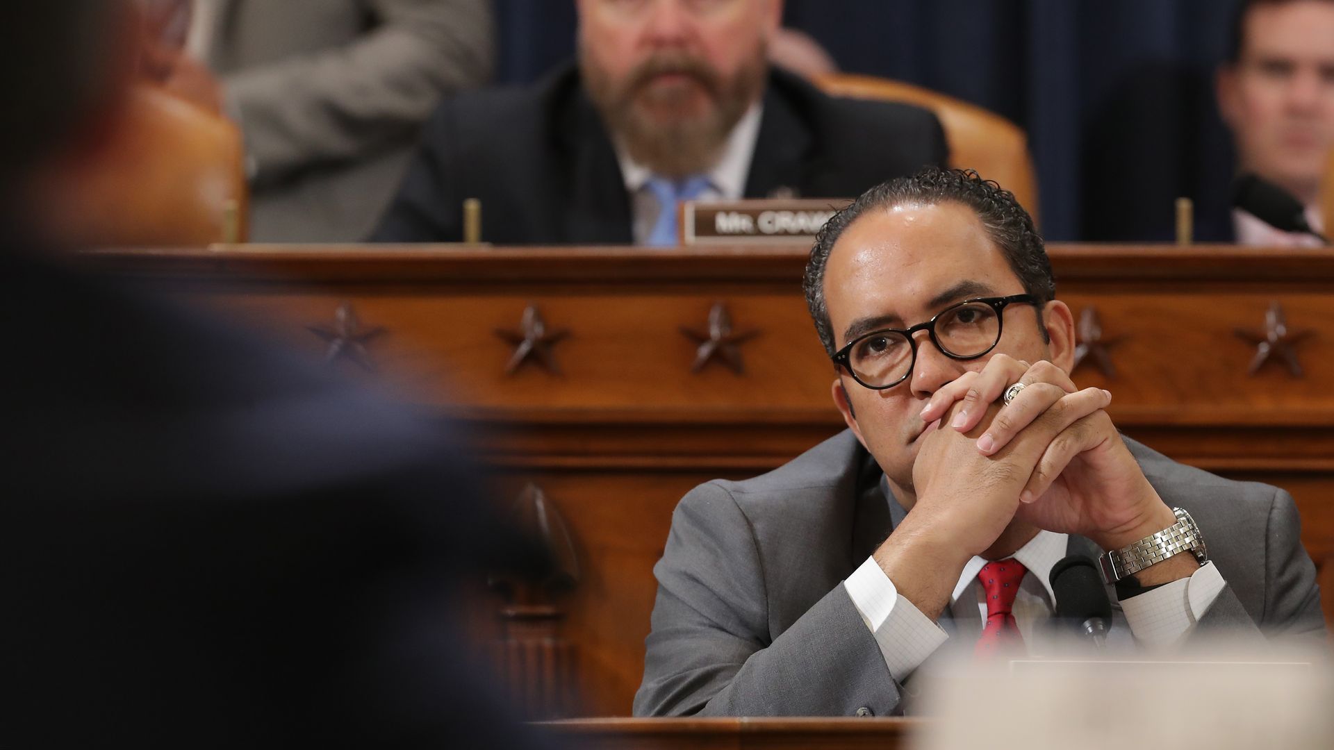 In this image, Hurd sits and listens during a hearing.