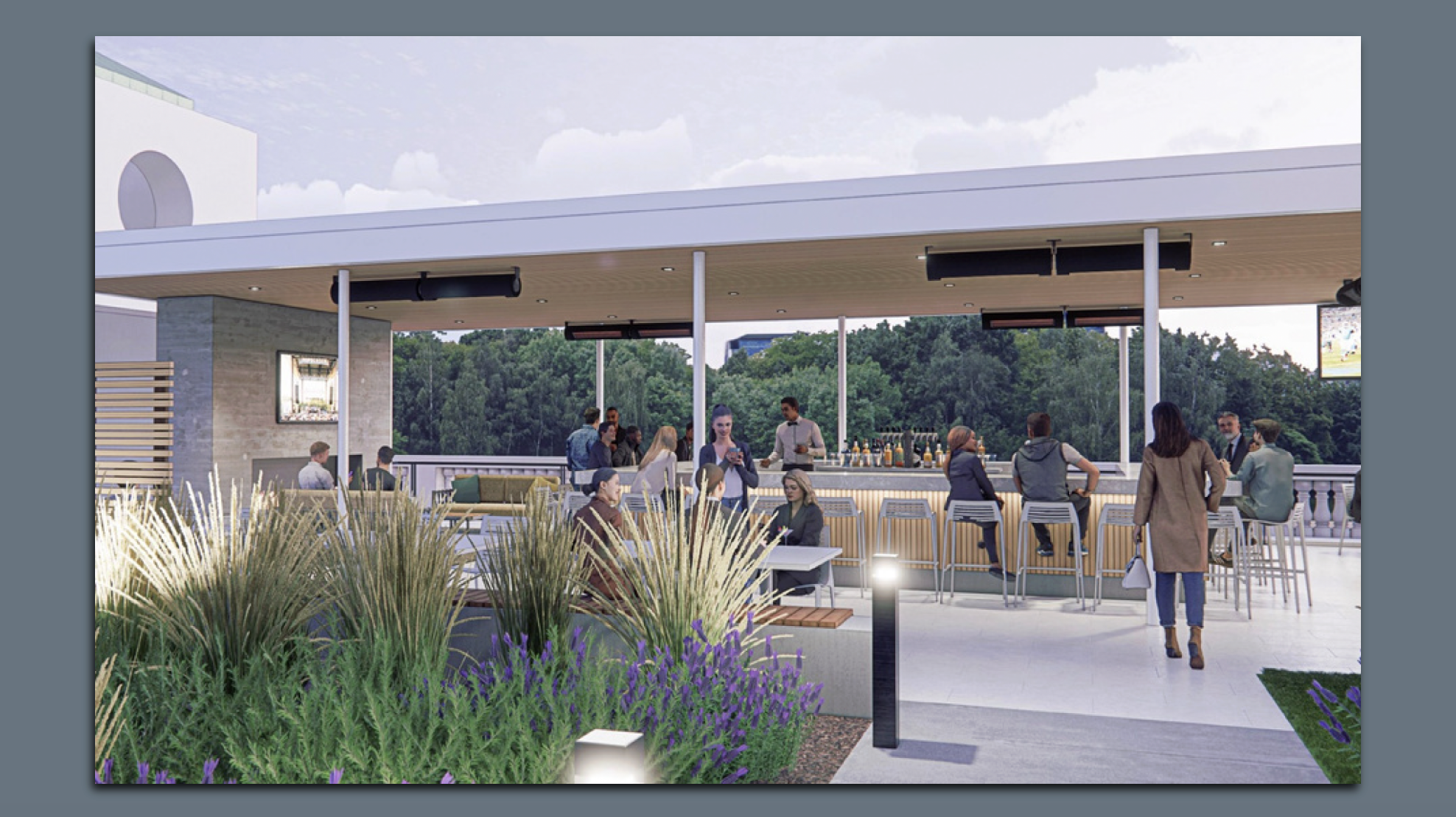 Outdoor rooftop bar with people socializing, sitting at tables and bar stools under a white canopy, surrounded by tall greenery and purple flowers, with a forest backdrop. Laurel Park restaurant in Charlotte NC