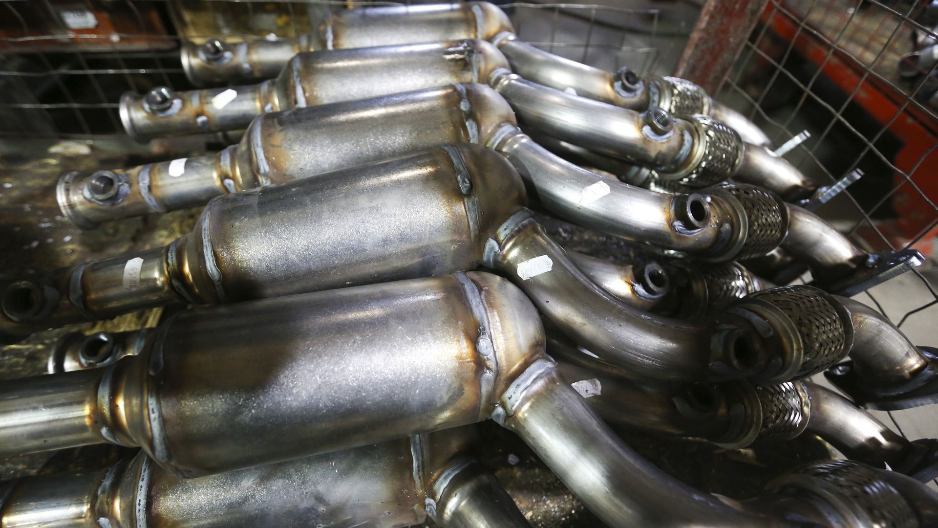 More than a dozen catalytic converters lay on top of each other.