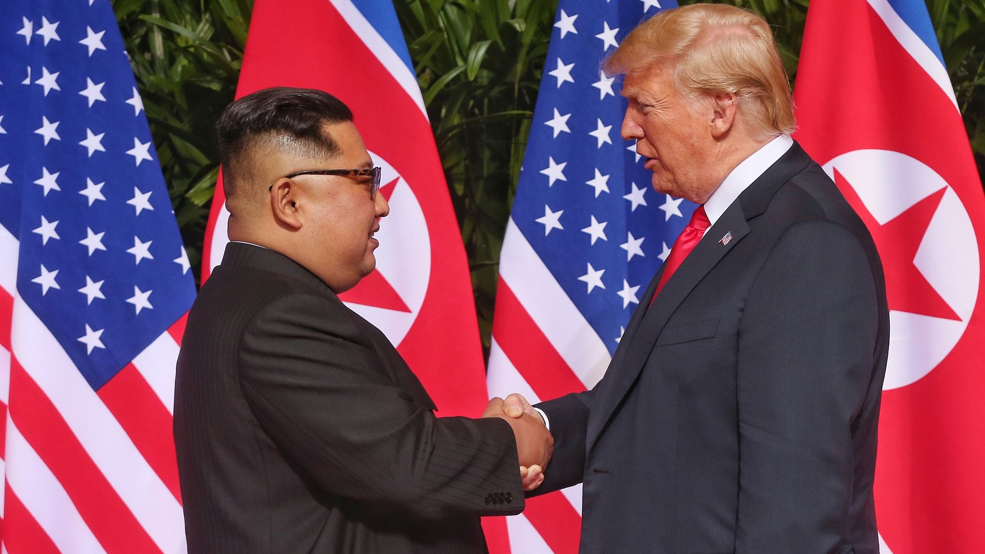 Donald Trump and Kim Jong-un shaking hands.