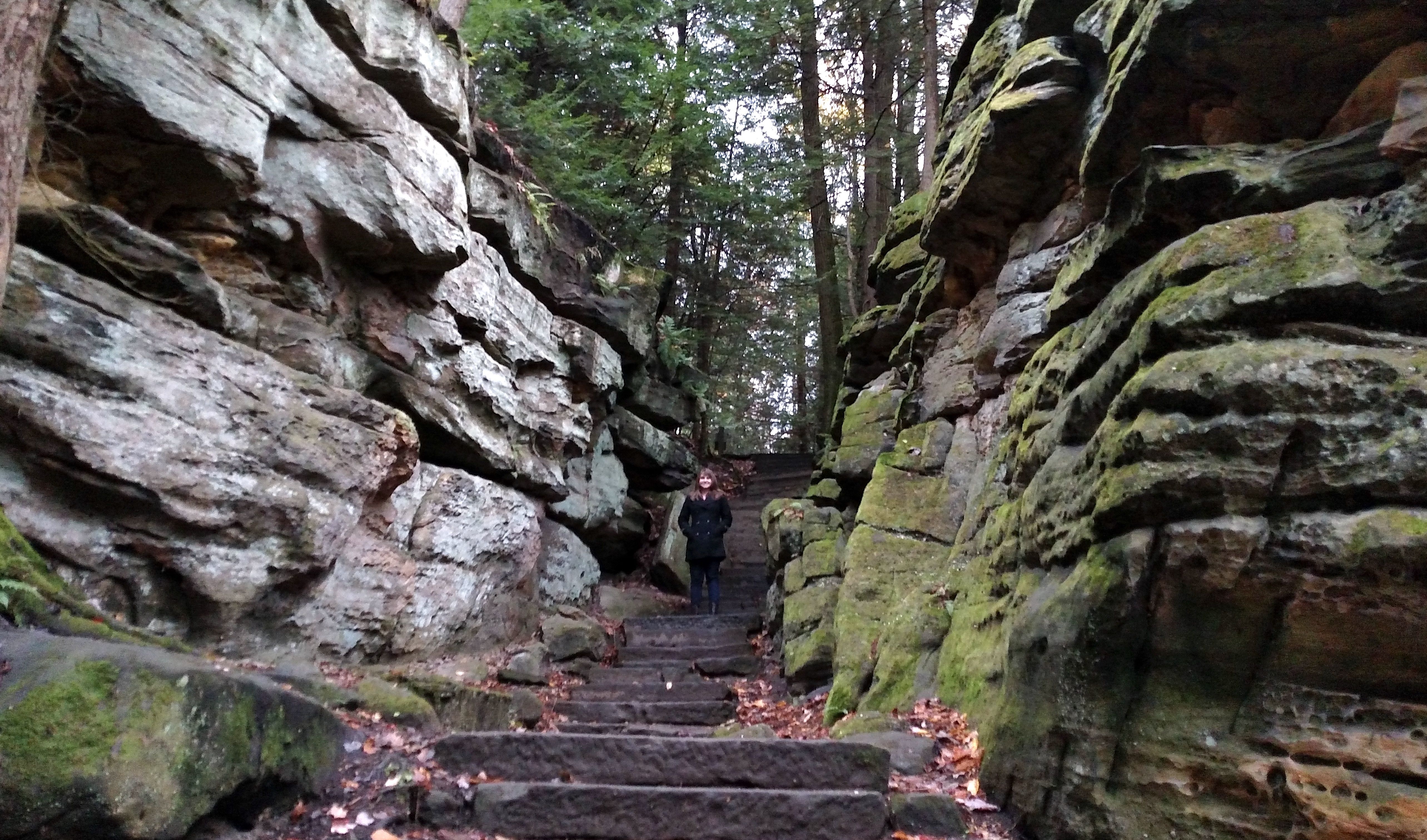 Alissa stands on the Ledges Trail's stone staircase with cliffs on either side