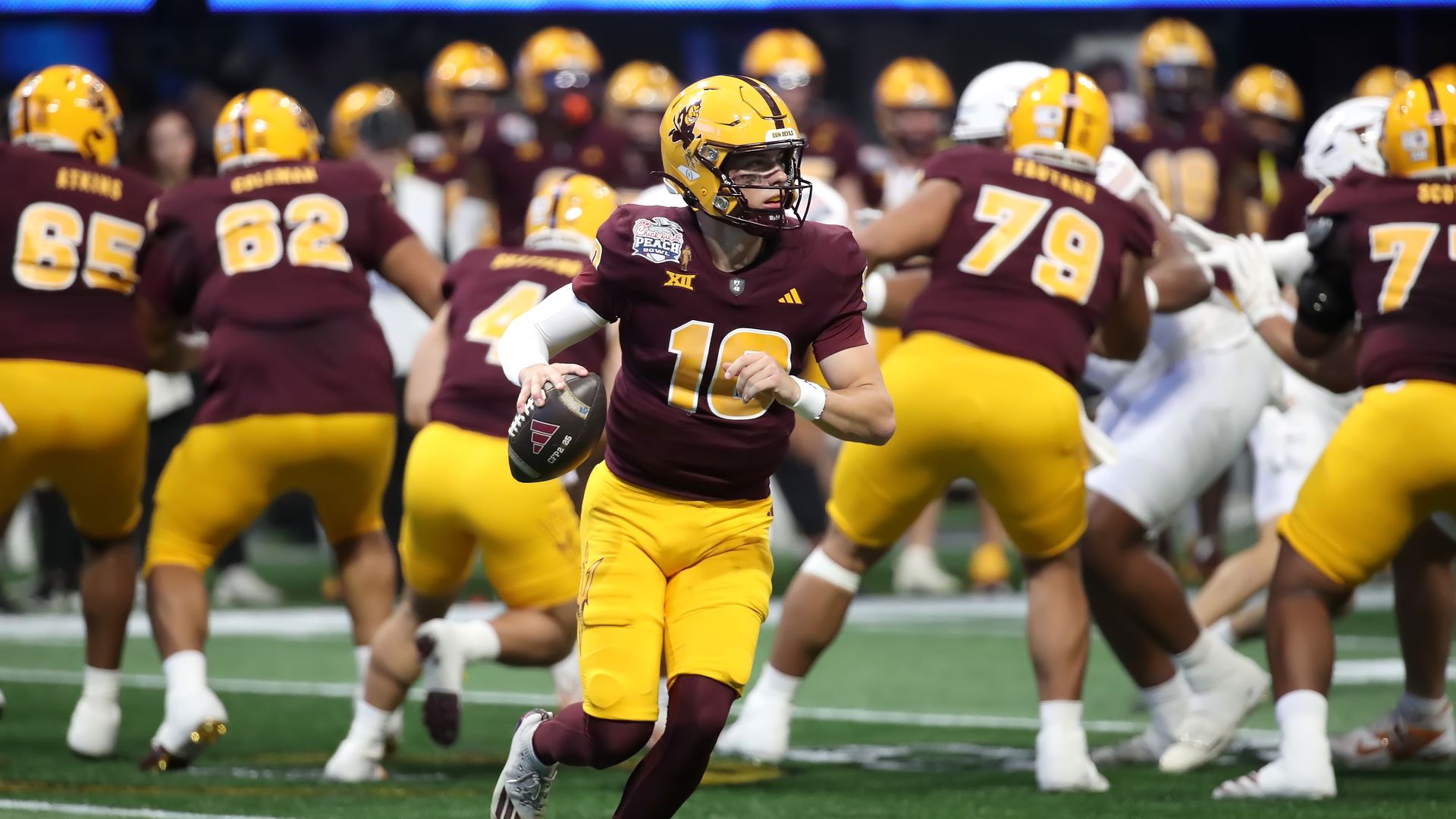 Arizona State quarterback Sam Leavitt running with the football, surrounded by teammates blocking opponents.