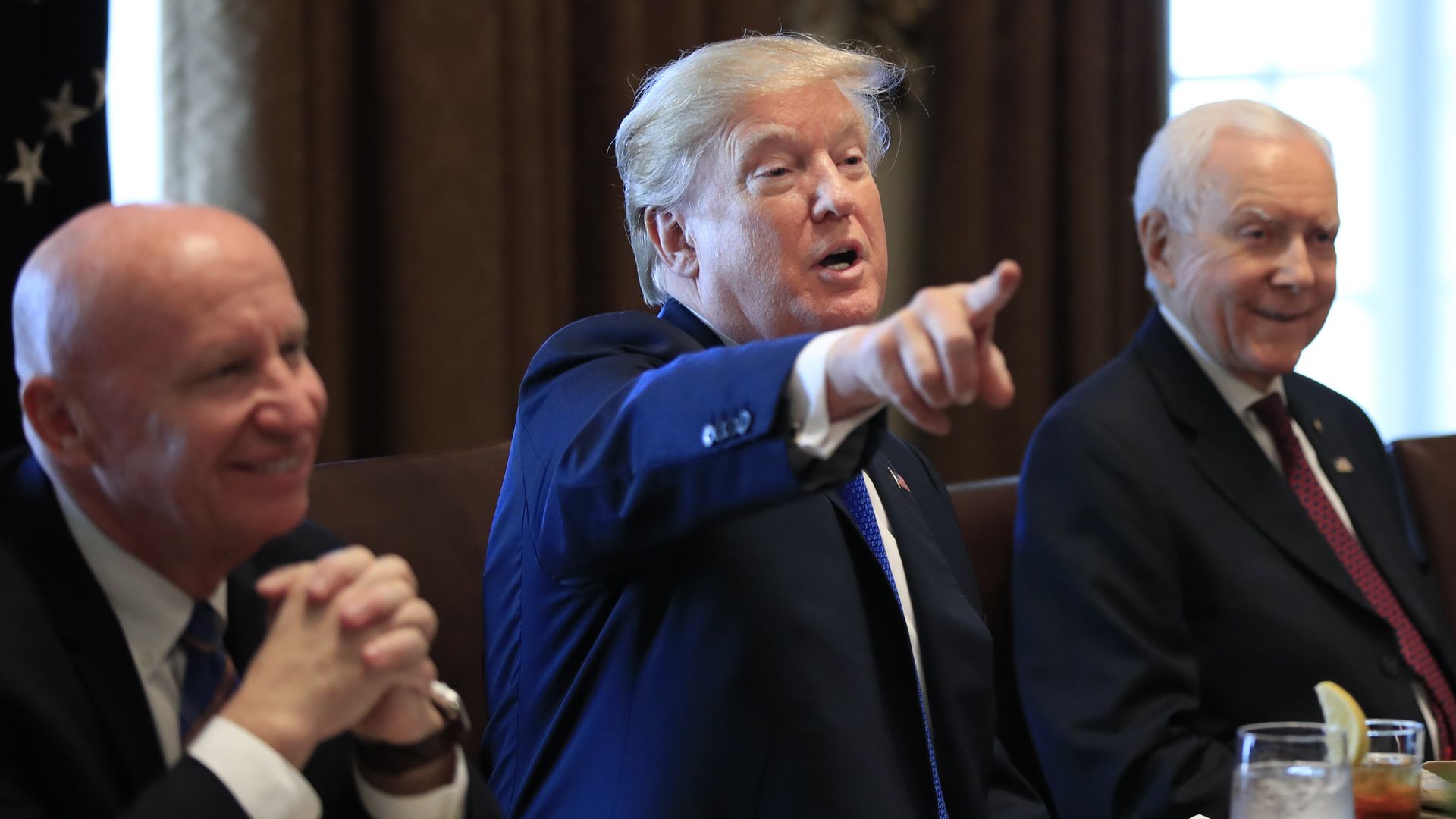 President Donald Trump, flanked by Rep. Kevin Brady, R-Texas, left, and Sen. Orrin Hatch, R-Utah, right.