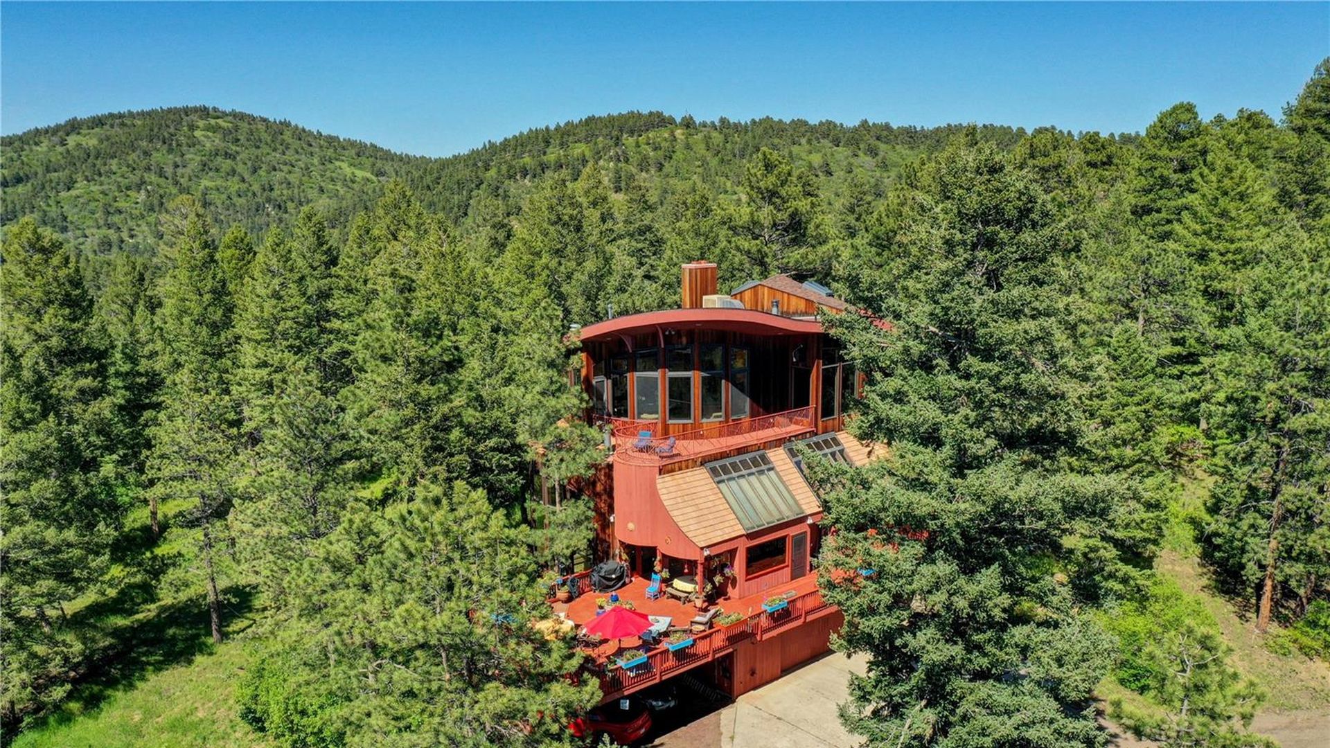 multi-story wood house surrounded by forest