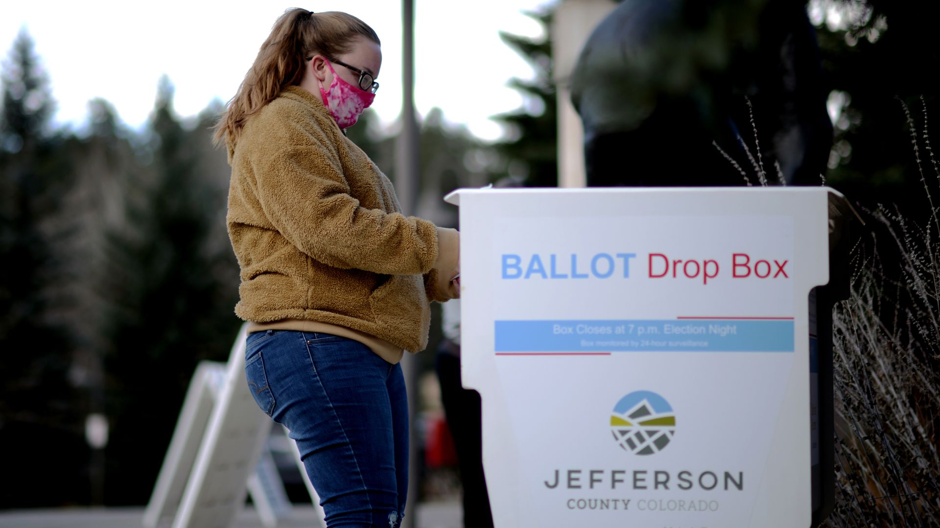 A voter puts a ballot into a drop box in Colorado.