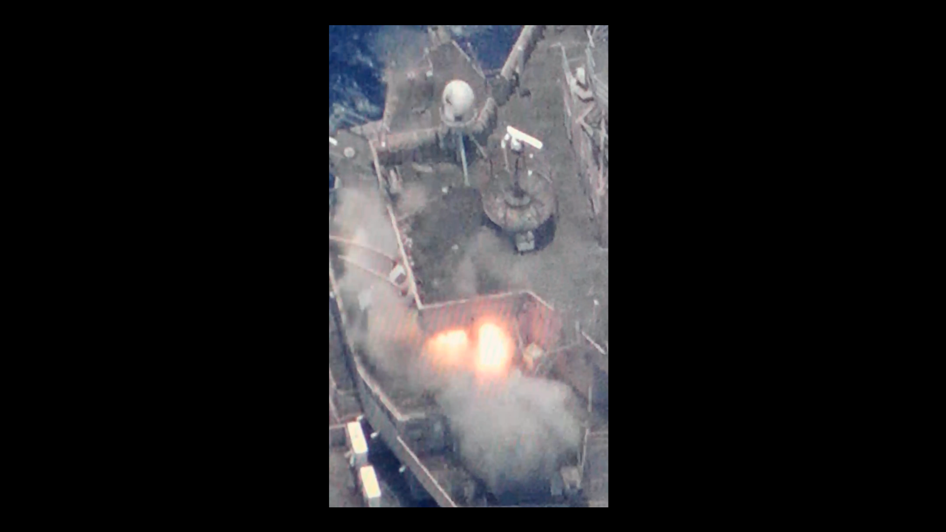An explosion is seen inside the Dubuque warship. Blue water can be seen at the edges of the frame.