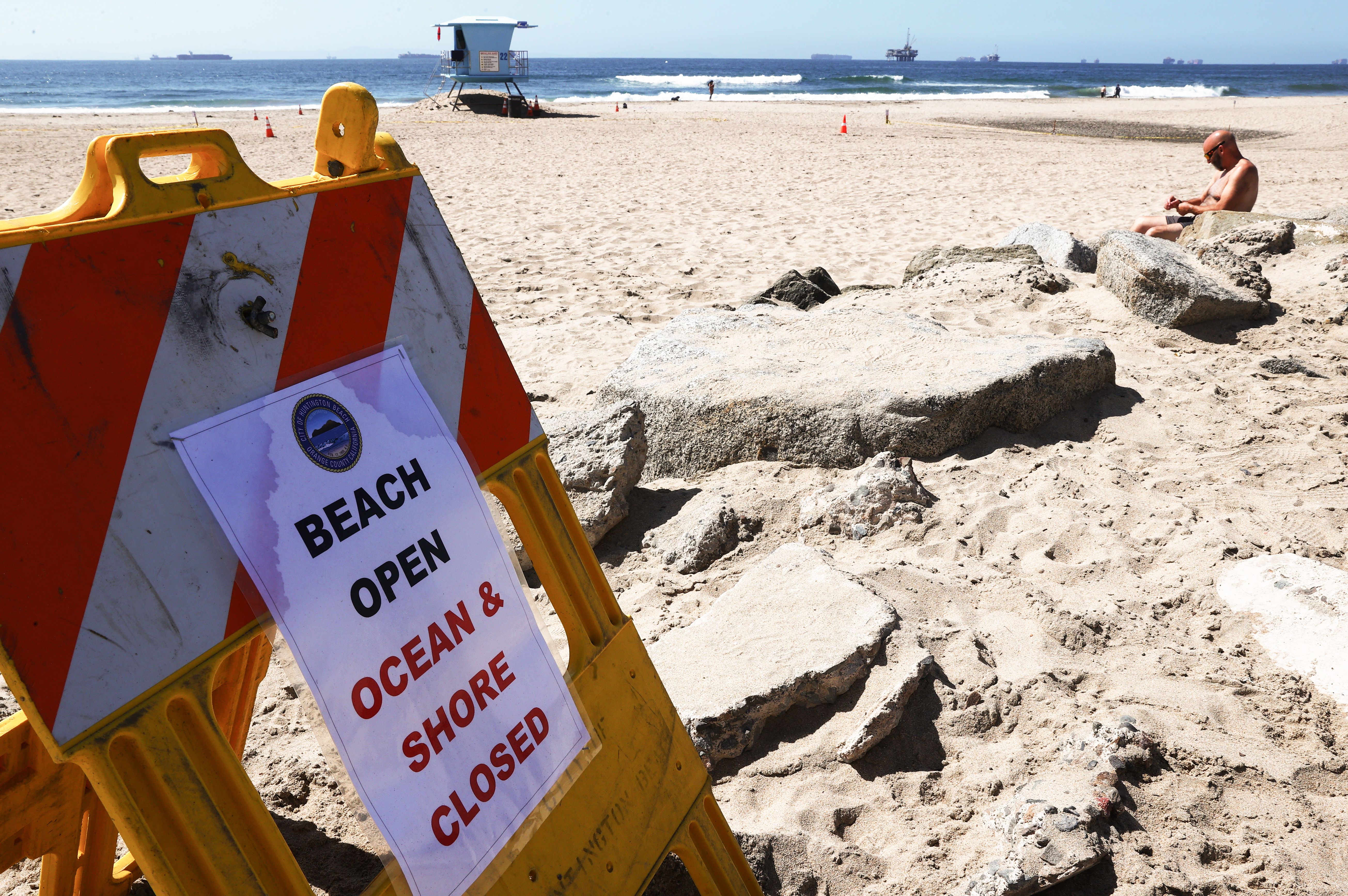  A person sits on a mostly empty Huntington Beach about one week after an oil spill from an offshore oil platform on Oct. 9 in Huntington Beach, California. 