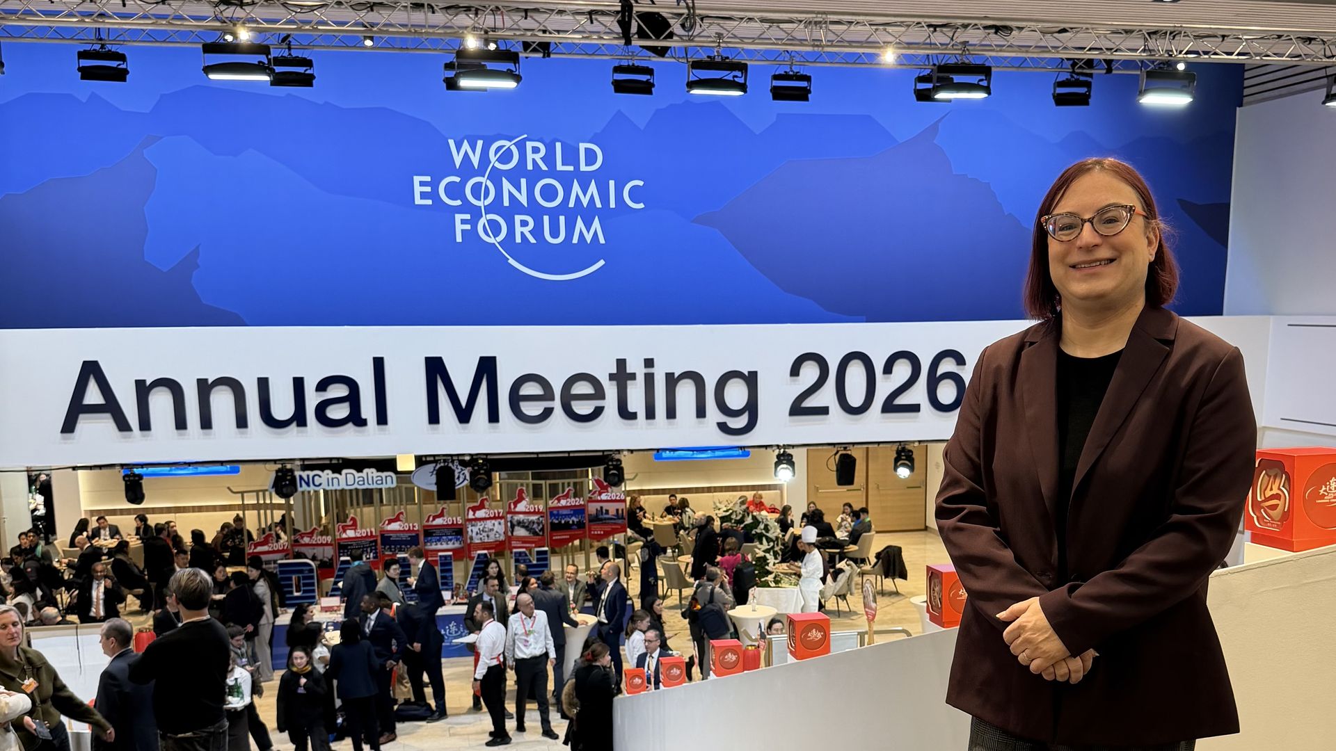 Axios' Ina Fried standing in front of a sign for the World Economic Forum's Annual Meeting 2026