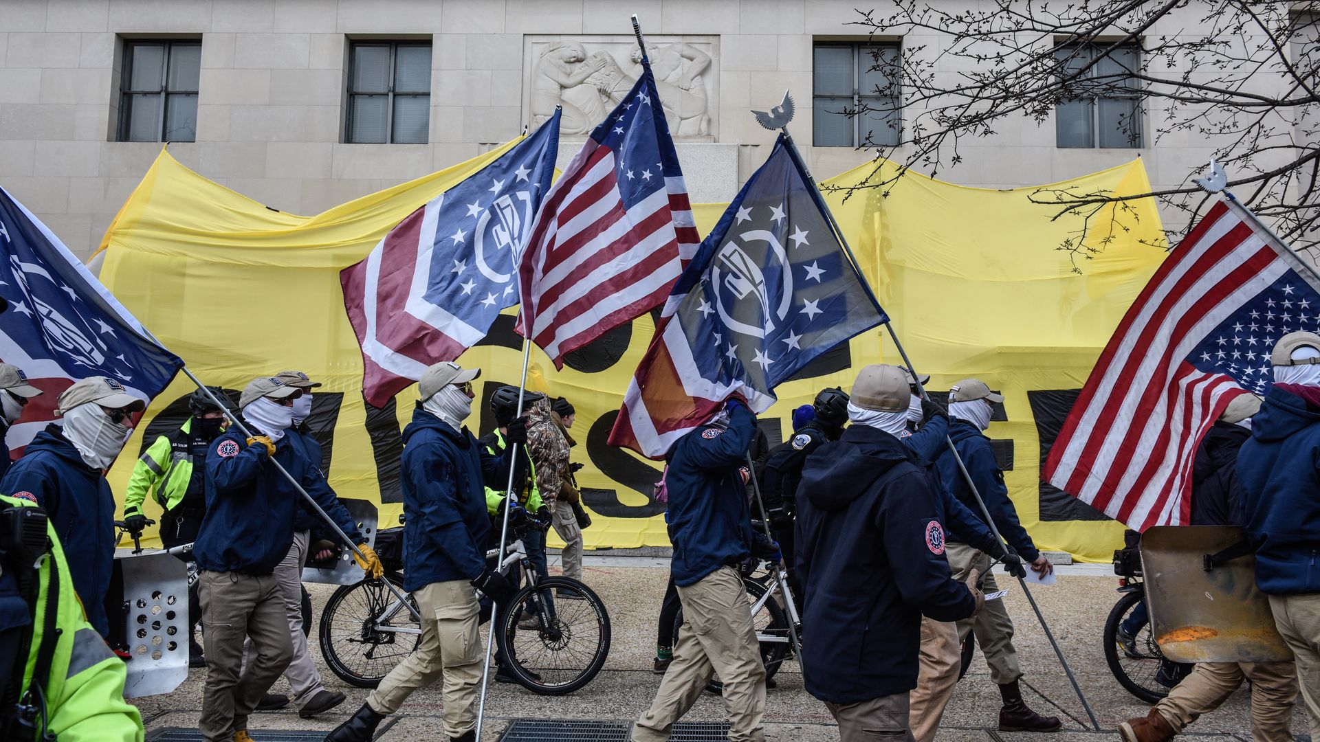 Members of Patriot Front hold flags 