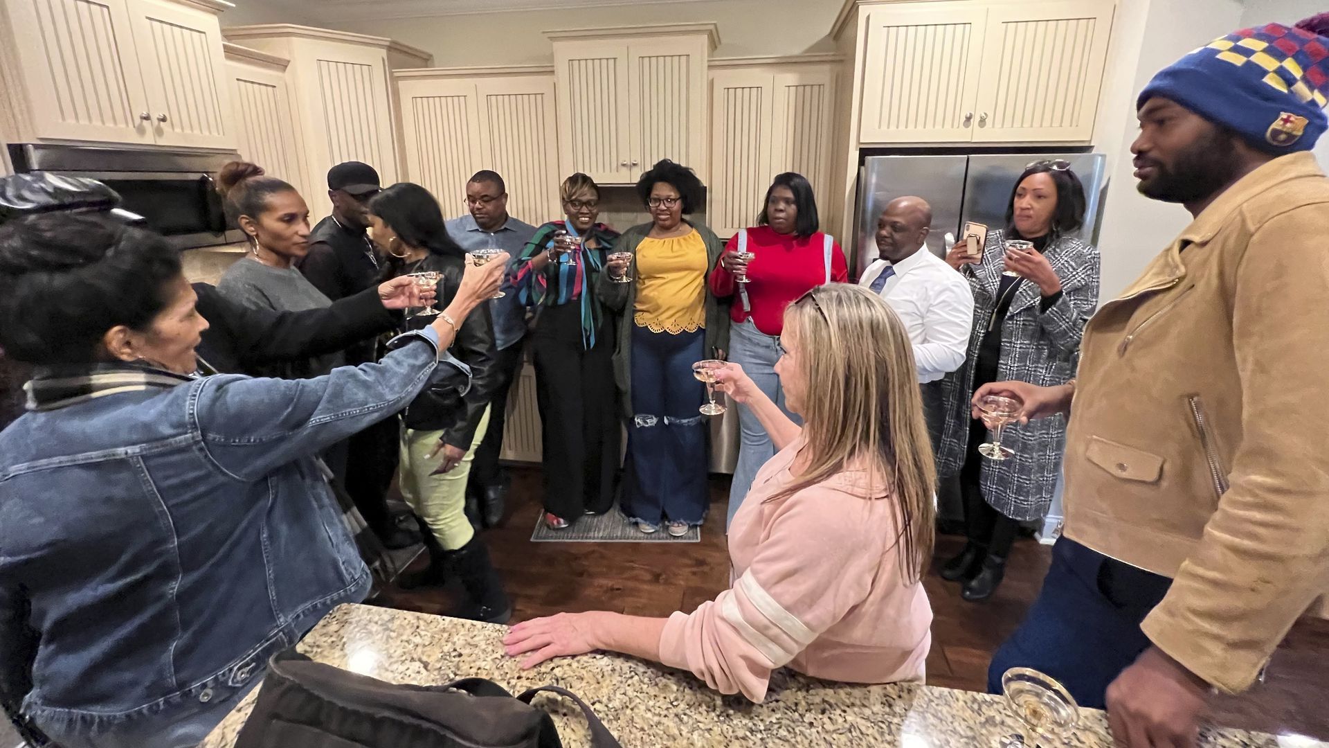 Wanda Cooper-Jones (striped scarf), mother of Ahmaud Arbery, toasts with family and friends on St. Simons Island, Ga., after the verdict.