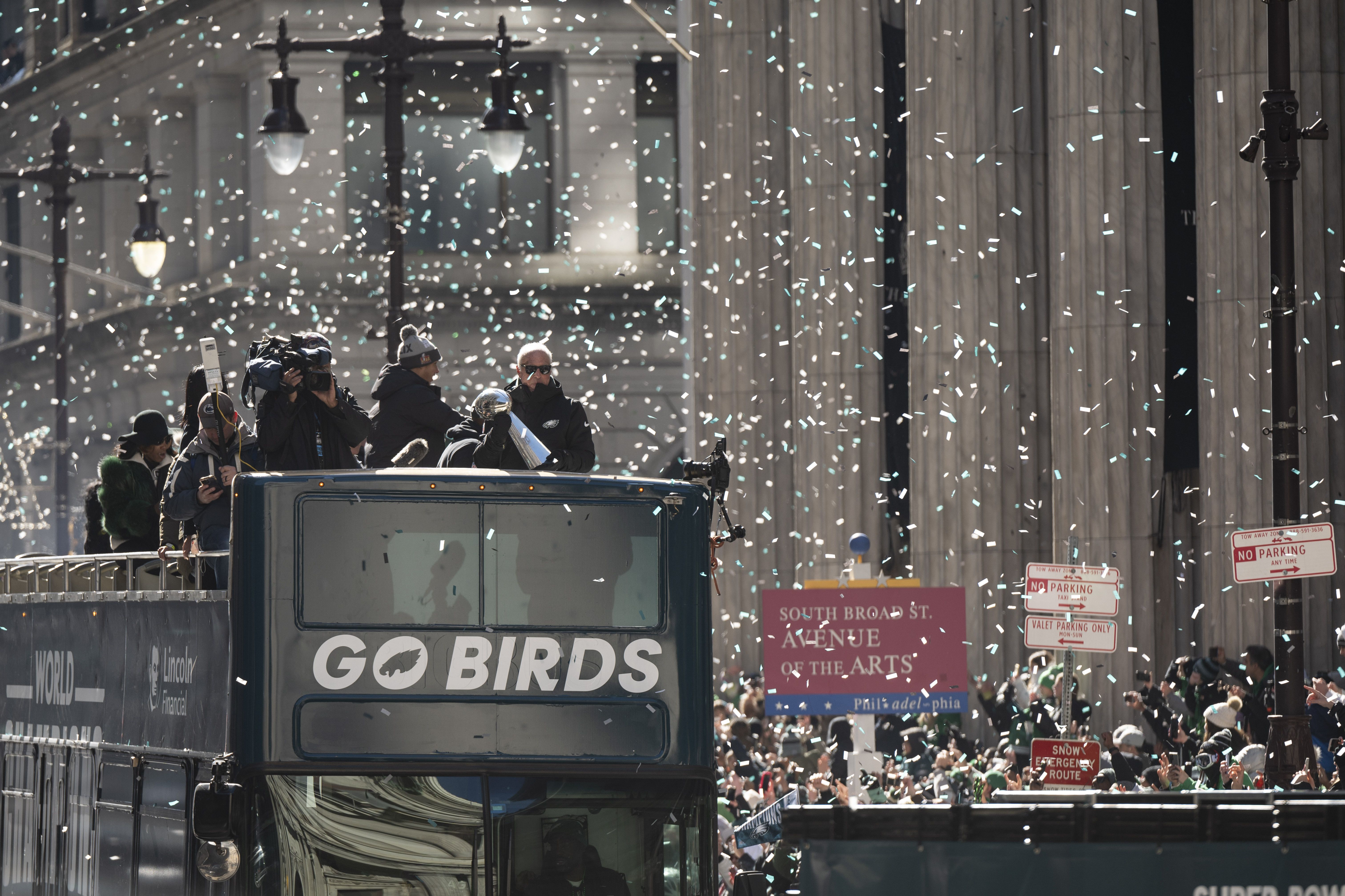 Confetti rains down on an open-air bus that says "Go Birds"