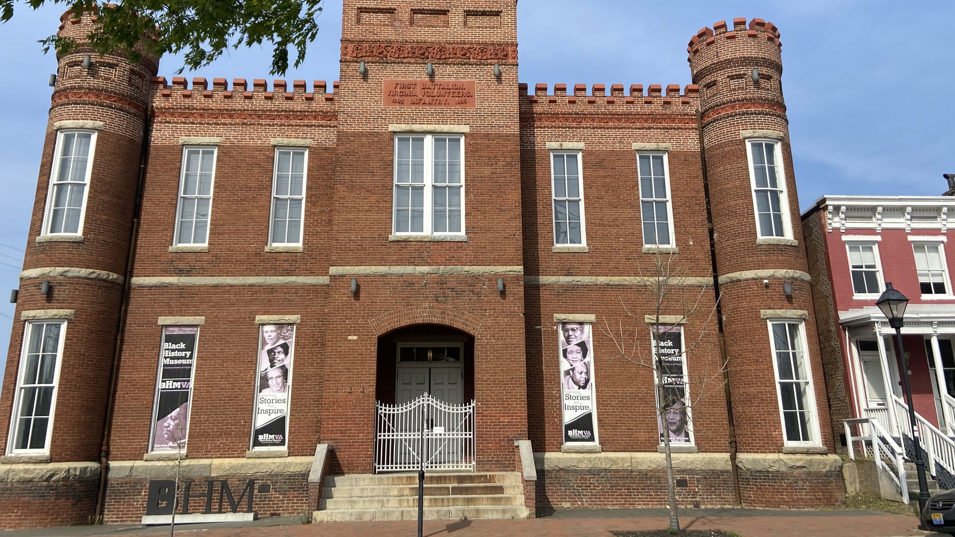 The outside of the black history museum of virignia , which is a 3-ish story gothic looking brick building. 