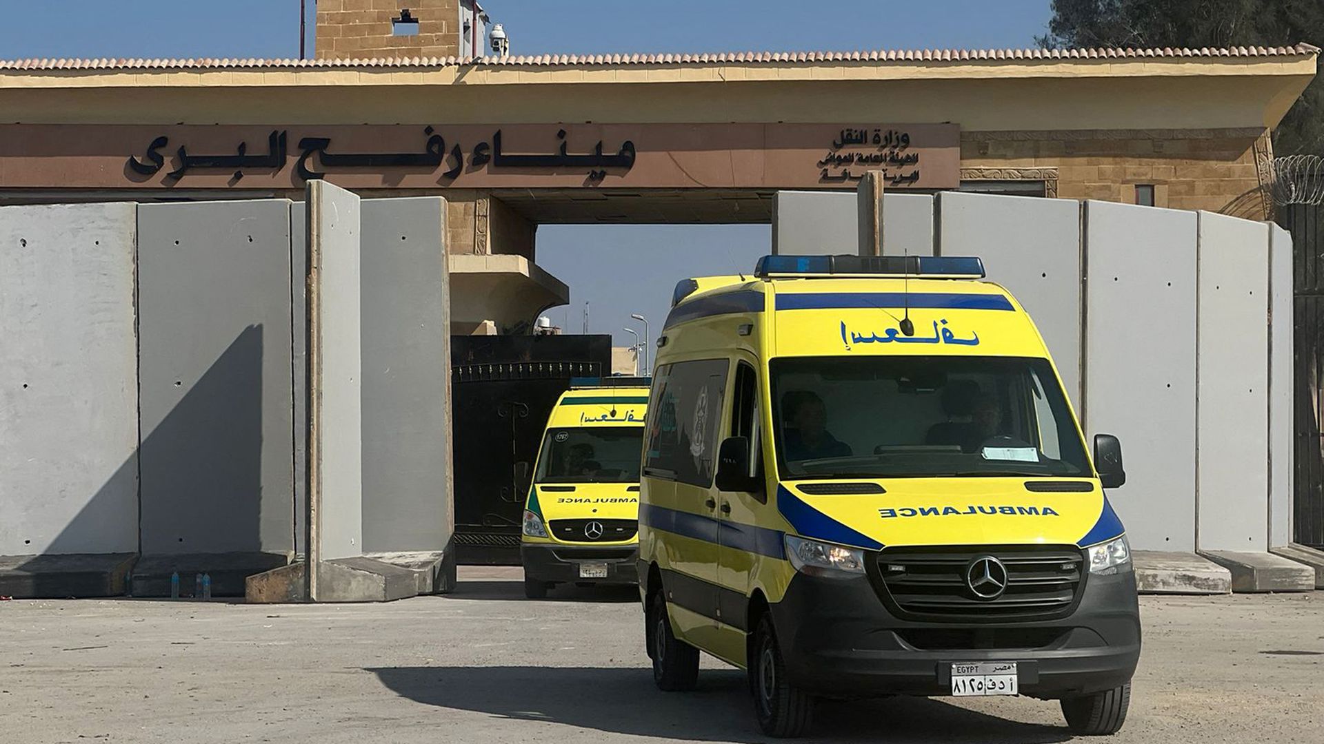 Yellow and blue ambulances transporting wounded Palestinians cross the border into Egypt.