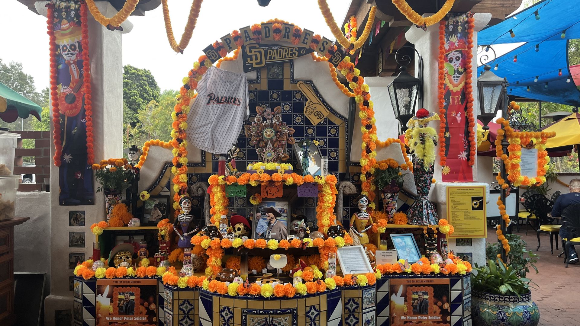 An ofrenda honoring Peter Seidler with marigolds, candles, skulls and Padres memorabilia. 