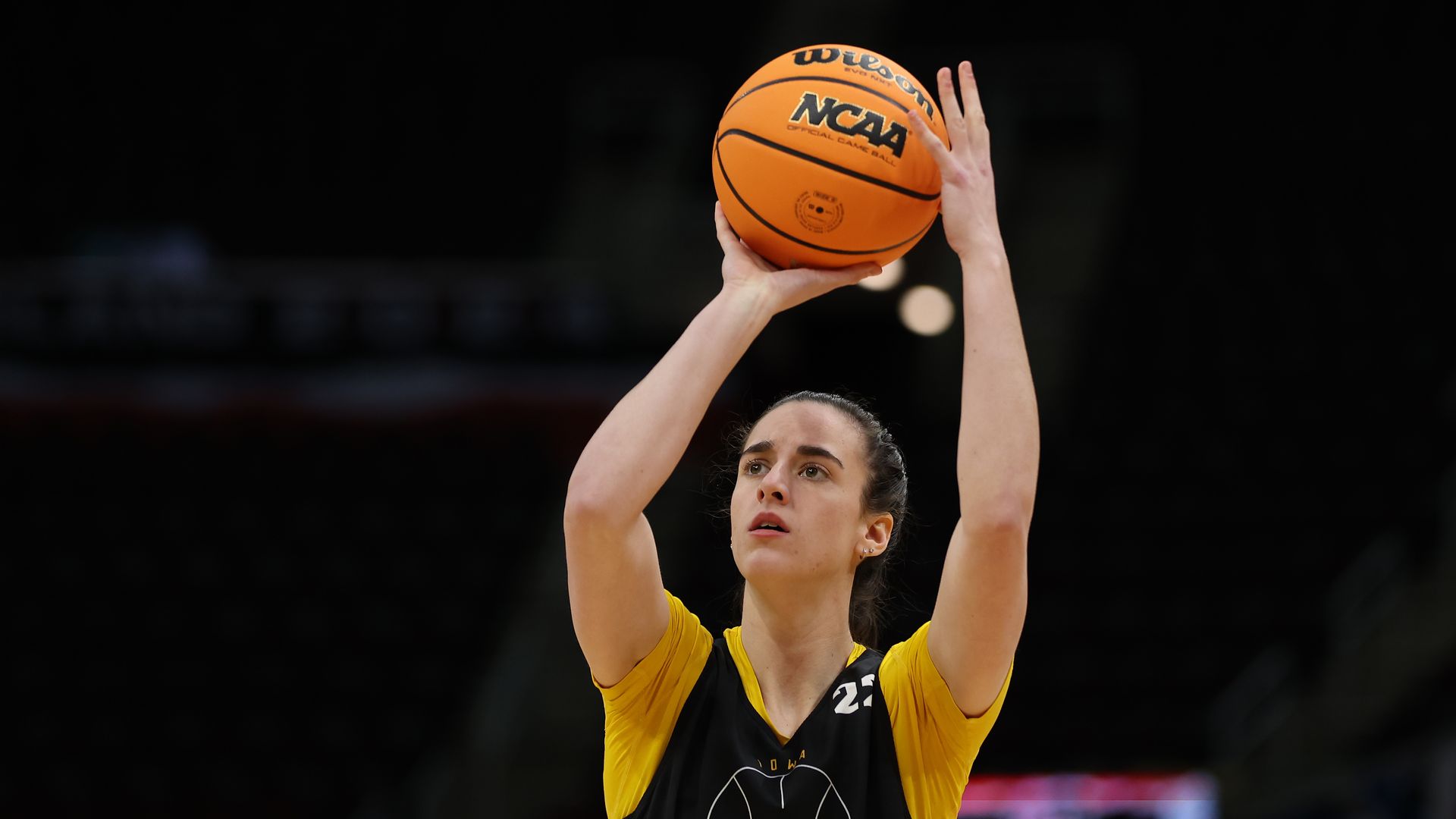 Caitlin Clark holds up a basketball