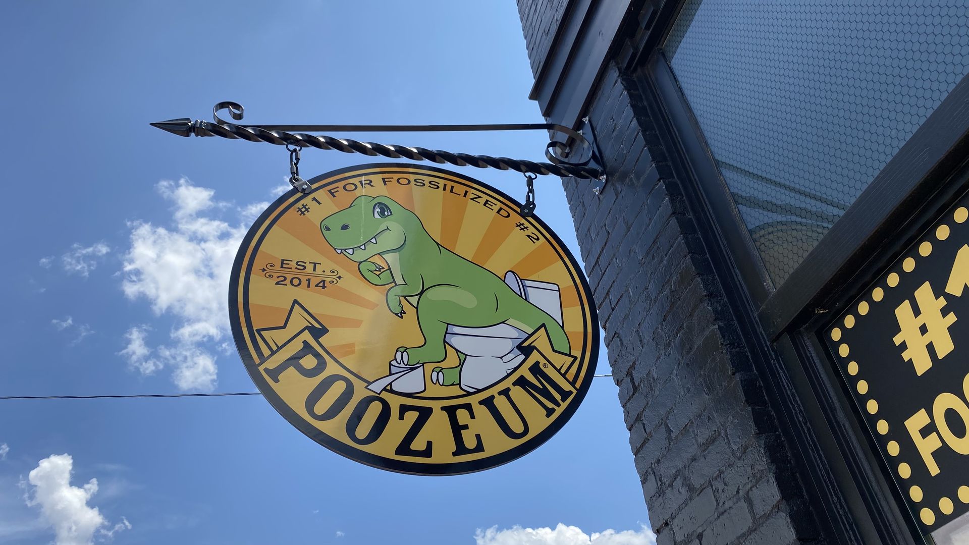 A sign that shows a dinosaur pooping and says, "Poozeum."