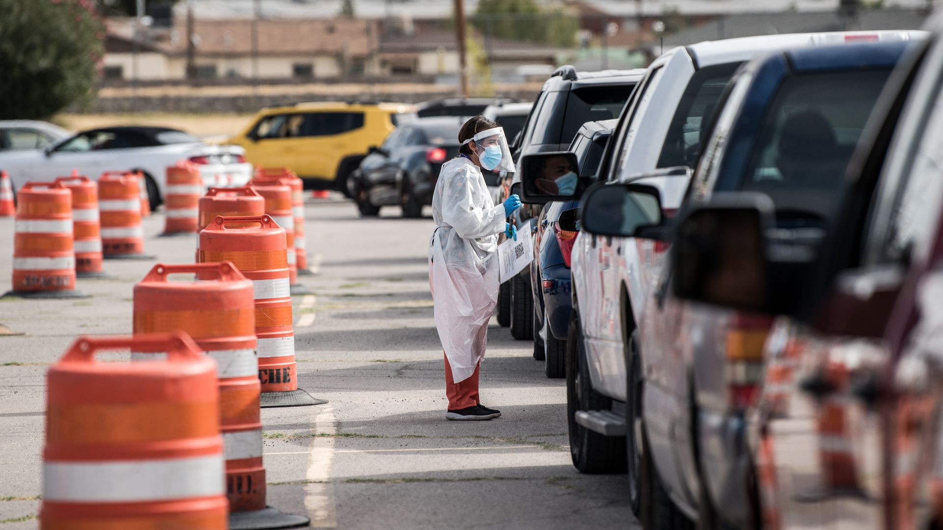 An attendant talks to a person waiting in their car at a coronavirus testing site at Ascarate Park