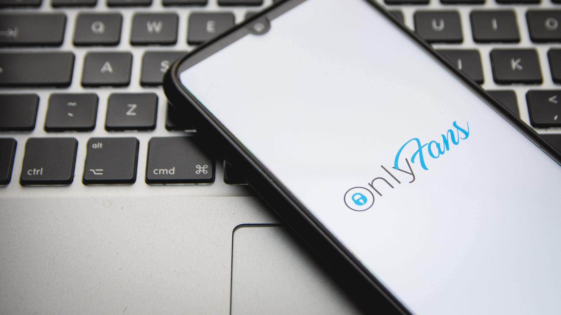 Picture of a smartphone with the OnlyFans logo displayed on the screen