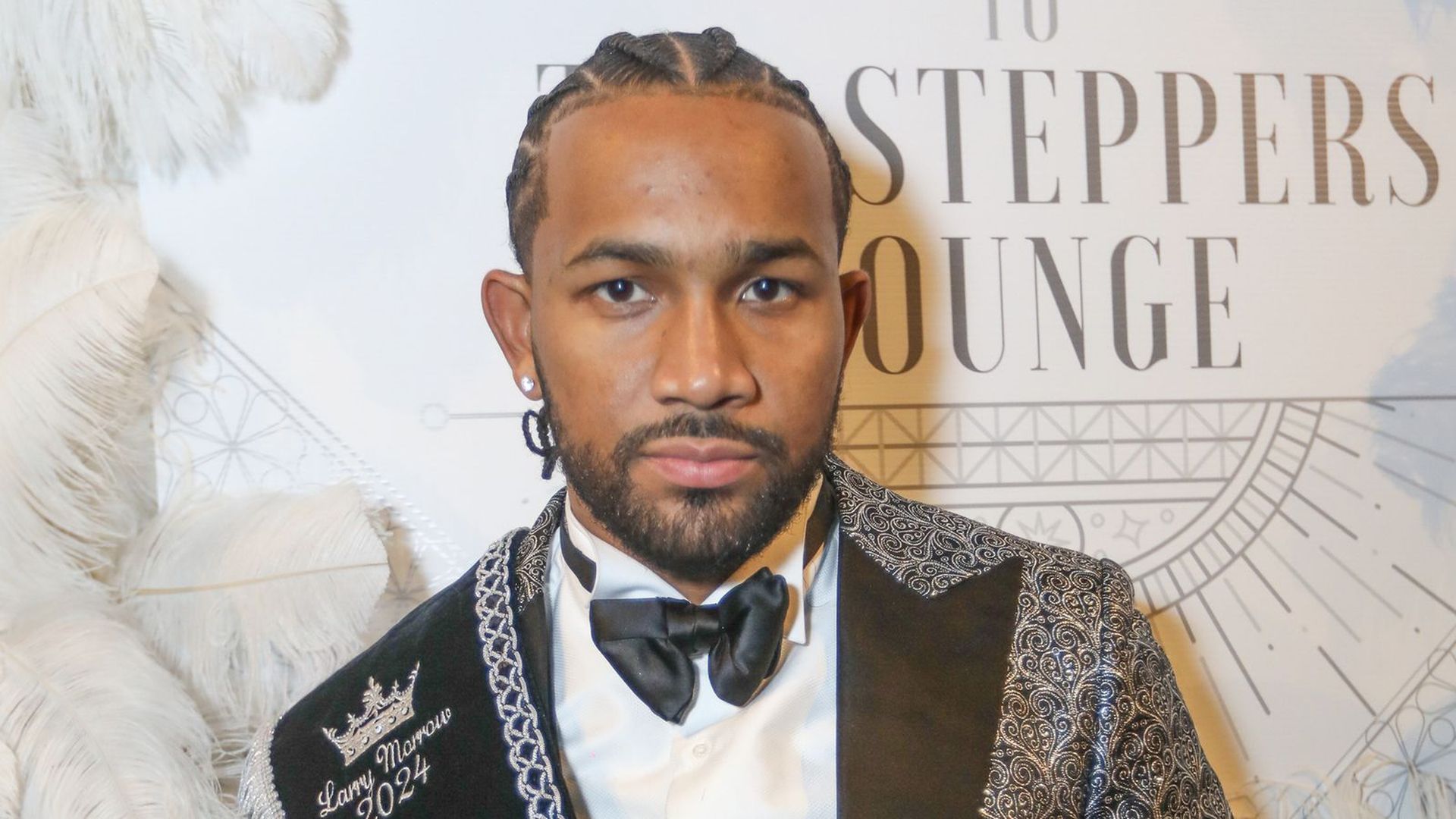 A photo of Larry Morrow posing on a red carpet.