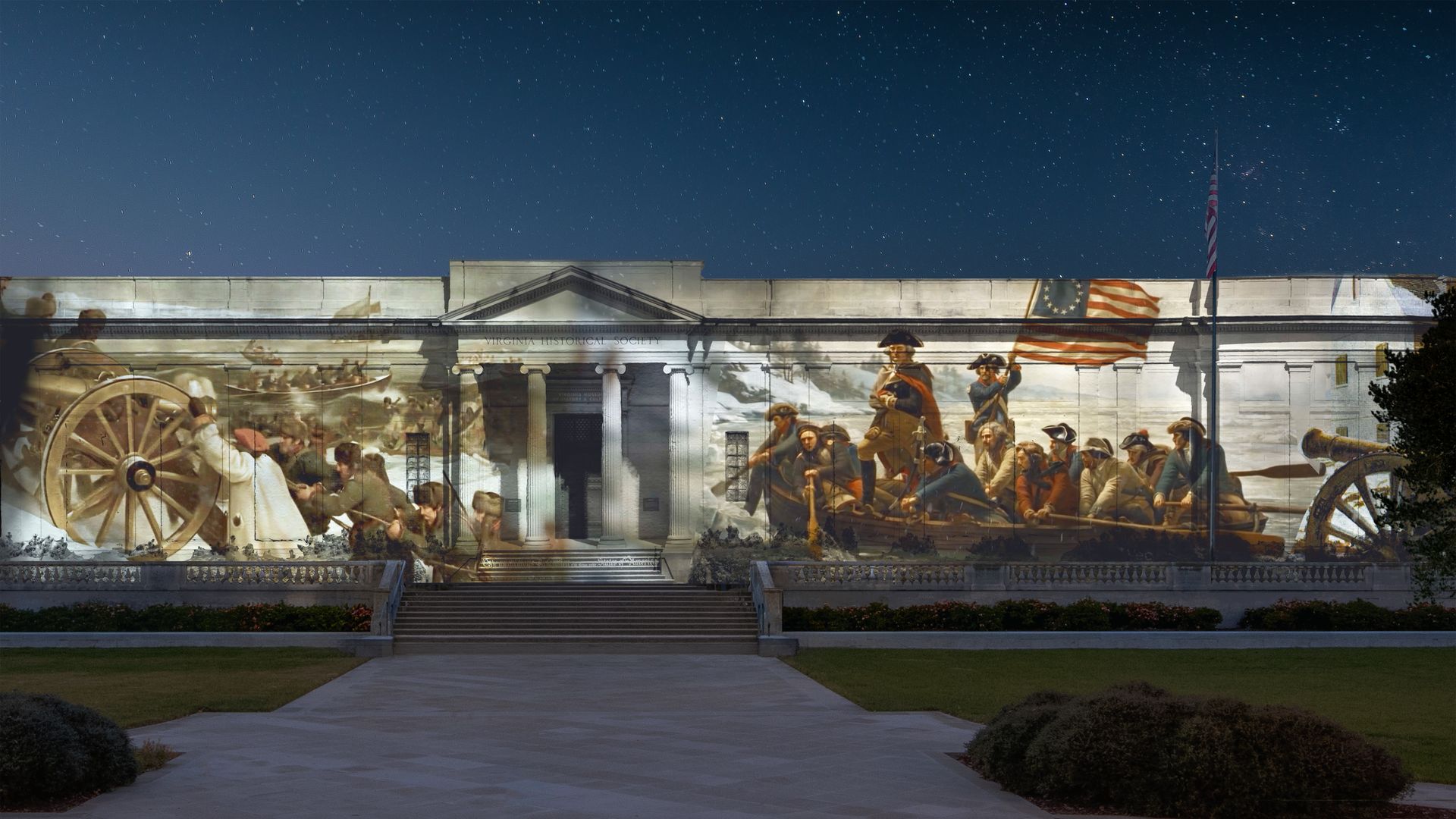 Night view of the Virginia Historical Society building with a large mural of Revolutionary War scenes across the facade, including cannons, soldiers, and an American flag; starry sky above.