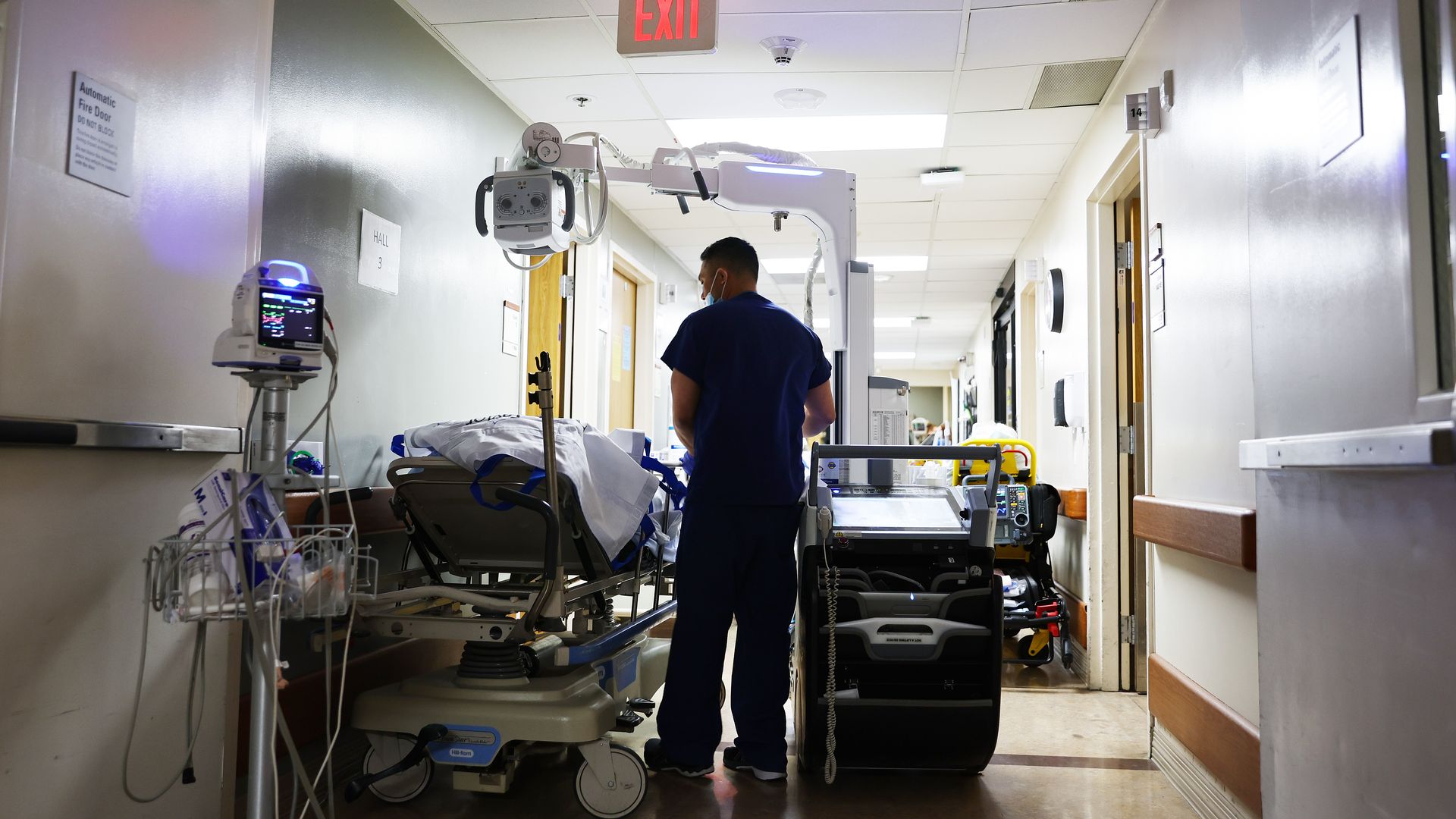 Photo of a nurse looking at a patient lying in a hospital bed