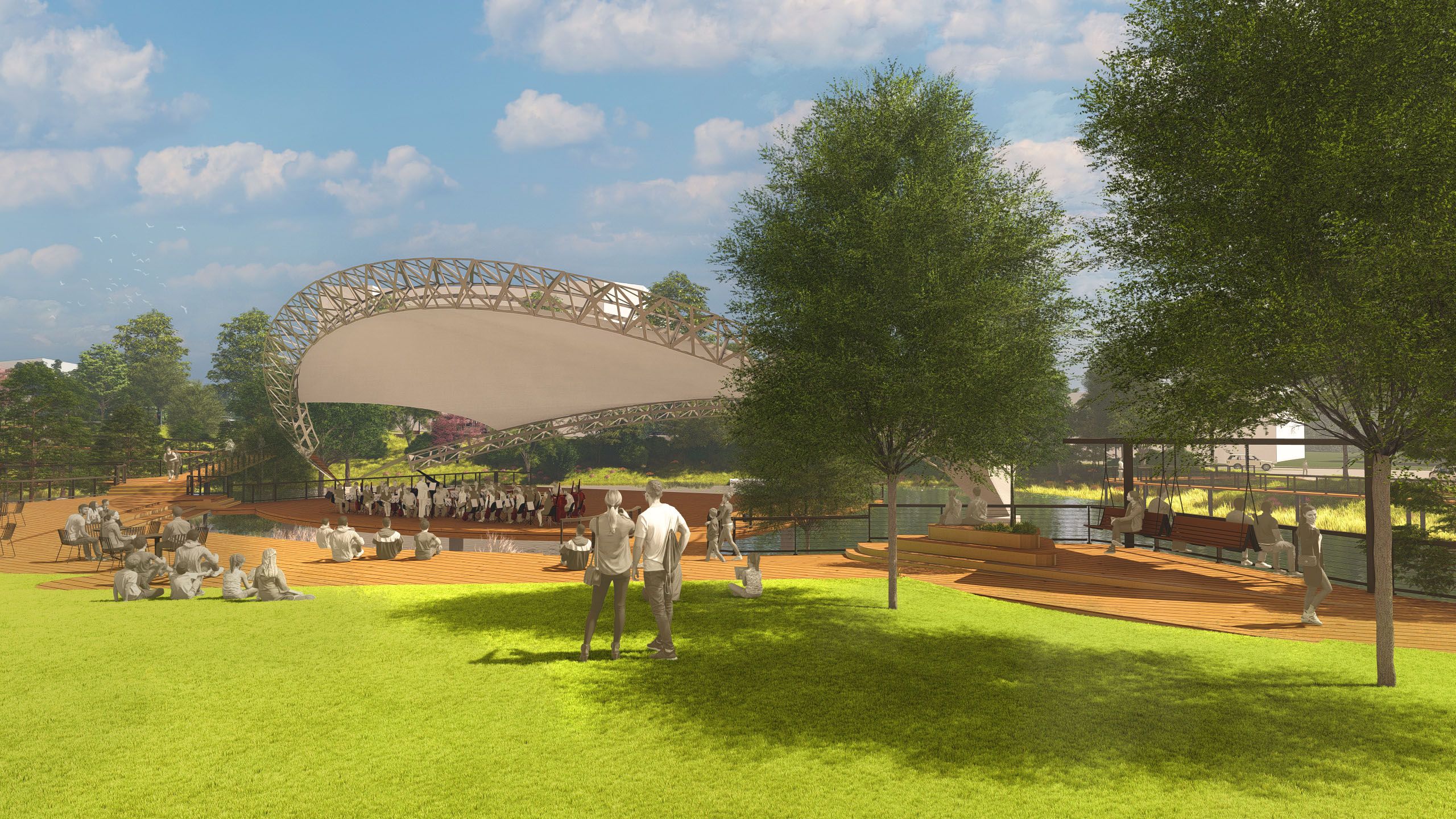 Outdoor amphitheater with a modern canopy over a stage where musicians perform. People sit on green grass and wooden decks, shaded by tall trees under a blue sky with clouds.