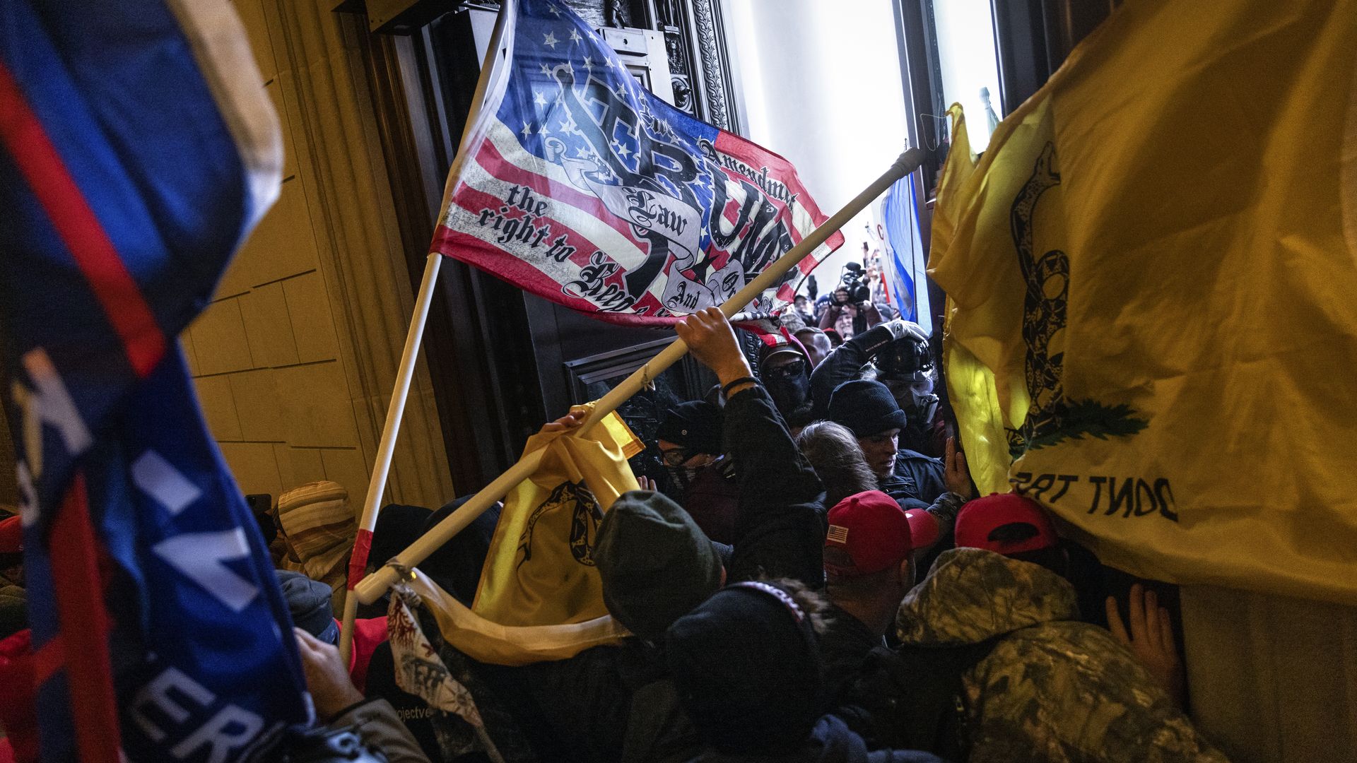 Photo of people storming the Capitol with flags and signs