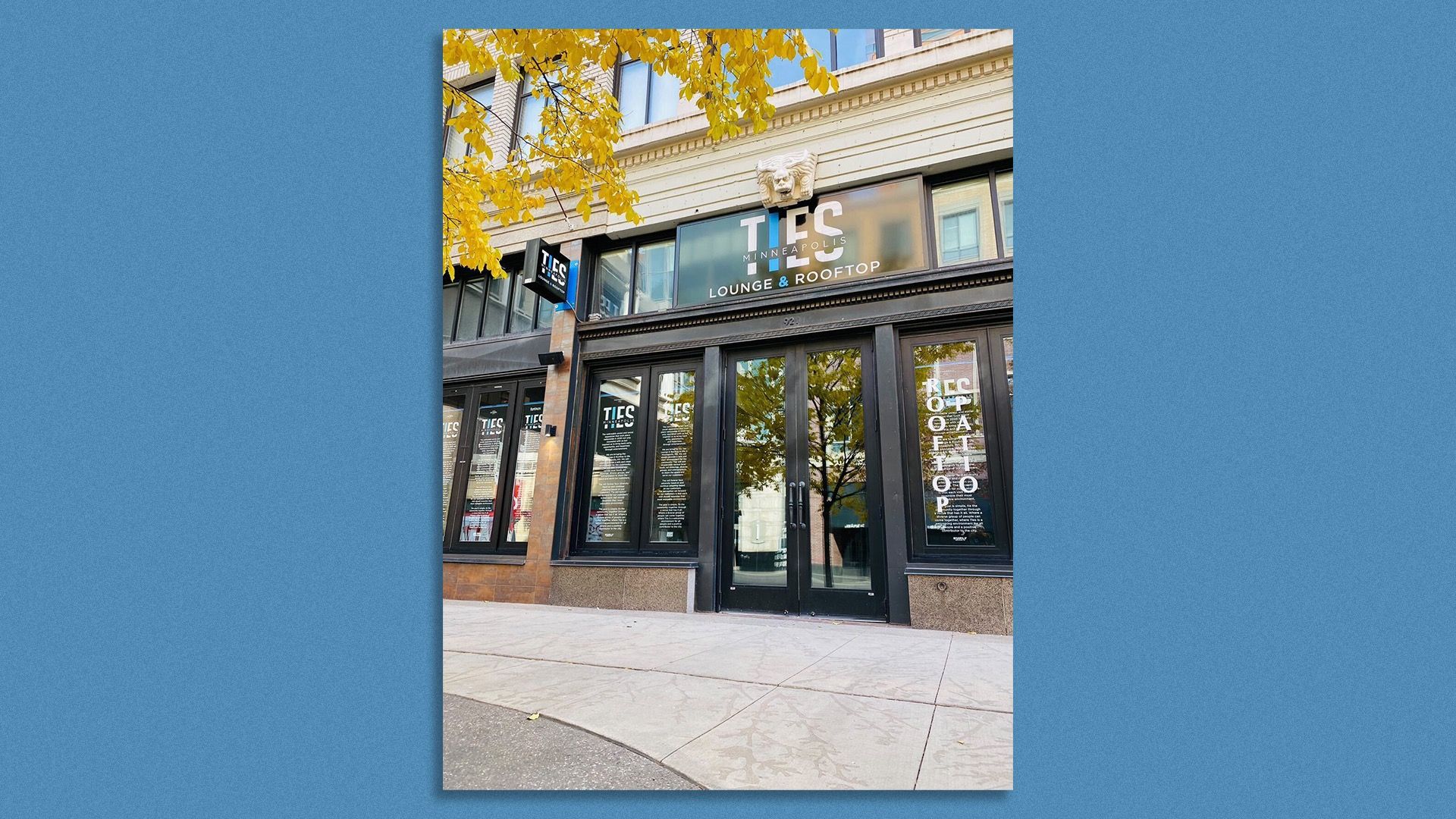 The exterior of a downtown Minneapolis. A sign with Ties Rooftop and Lounge is above the door. 