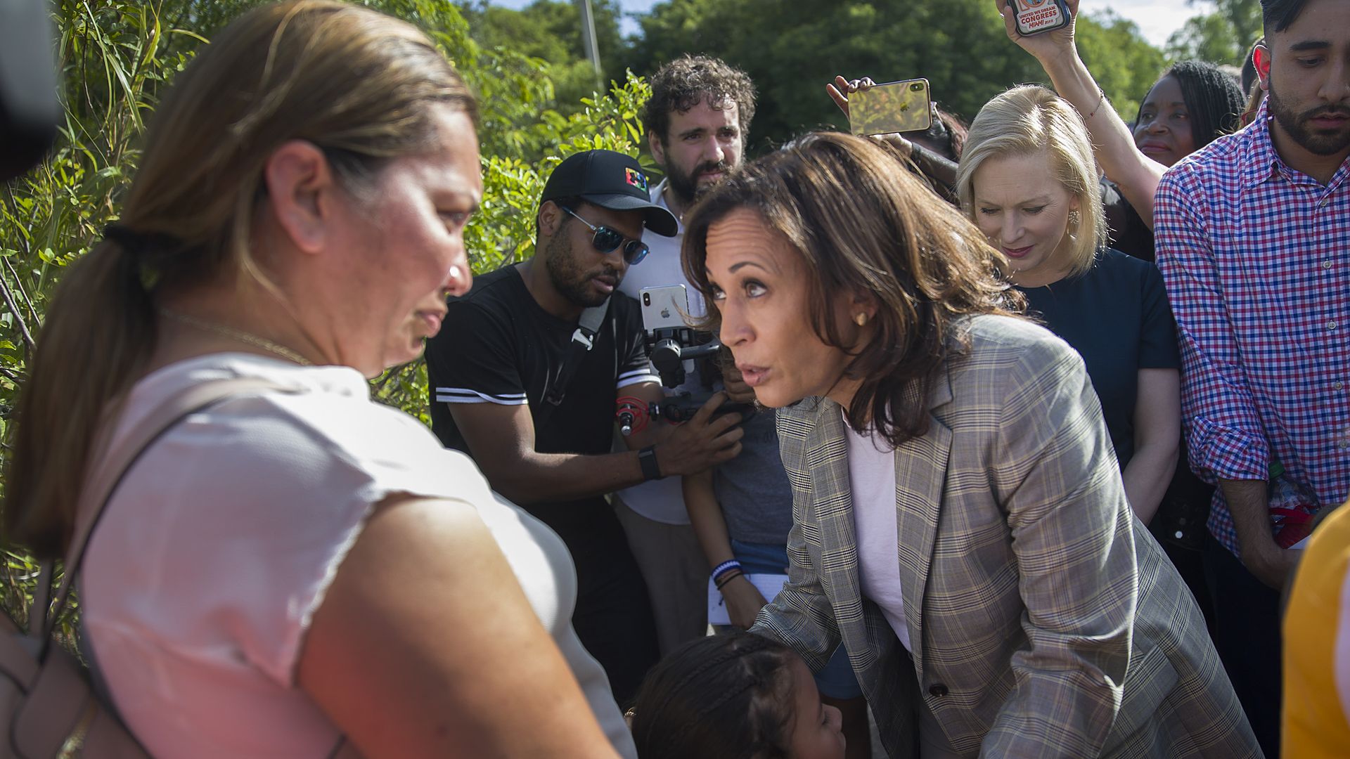 Then-U.S. Sen. Kamala Harris (D-CA) speaks with Lili Montalban and her daughter Roxanna Gozzer, as she visits the outside of a detention center for migrant children on June 28, 2019 in Homestead, Florida.