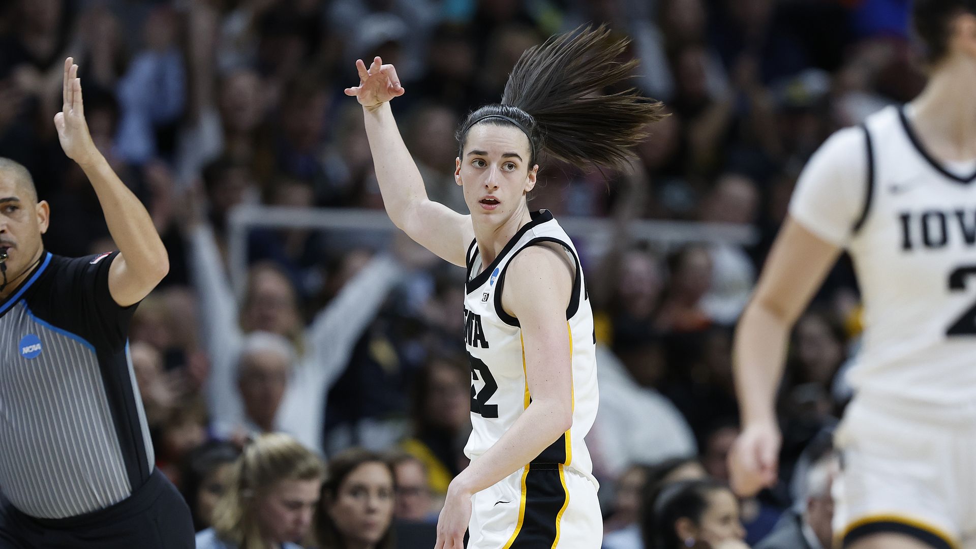 Caitlin Clark with her hand in the air