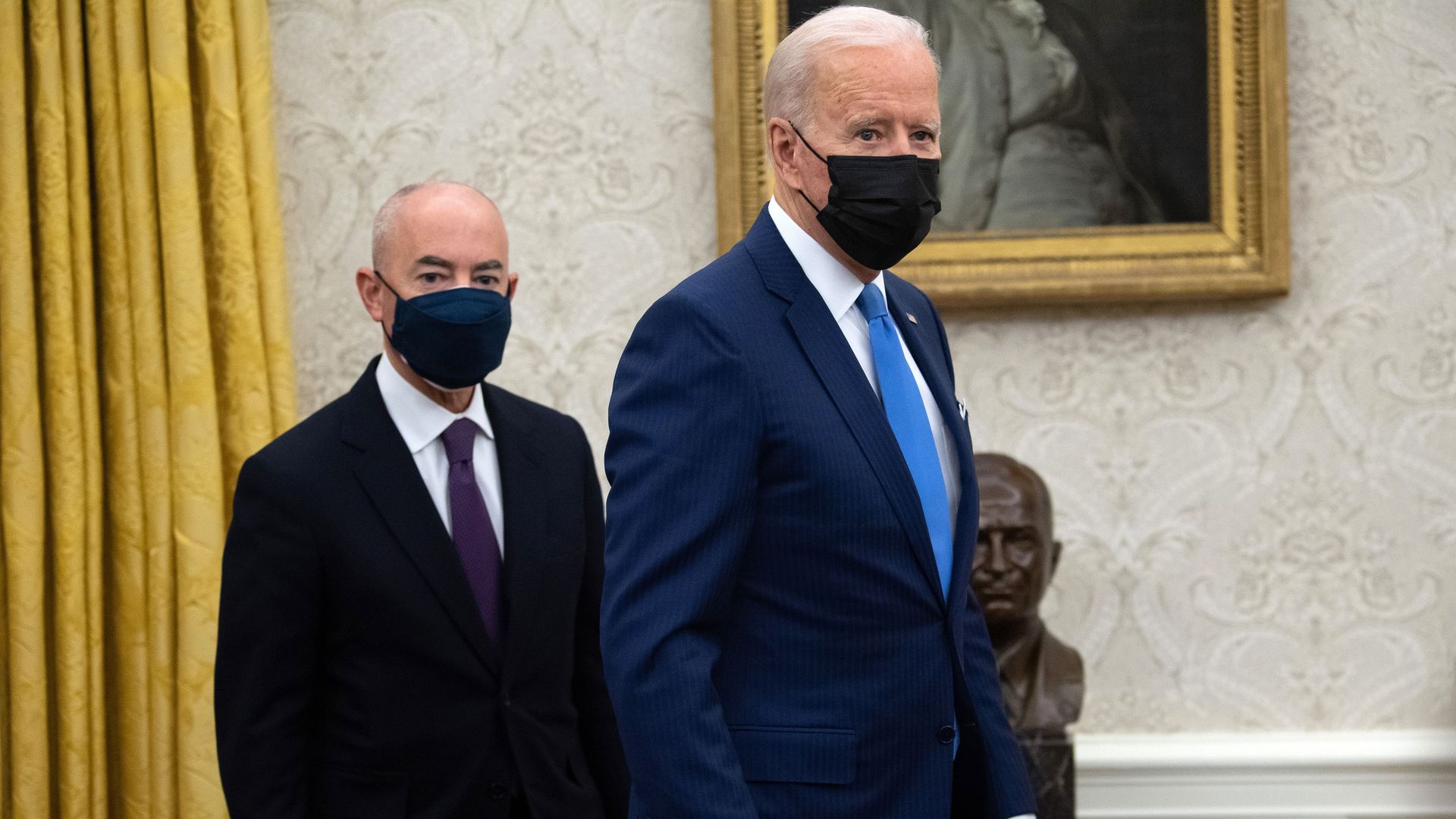 President Joe Biden stands alongside Secretary of Homeland Security Alejandro Mayorkas (L) after signing executive orders related to immigration at the White House February 2