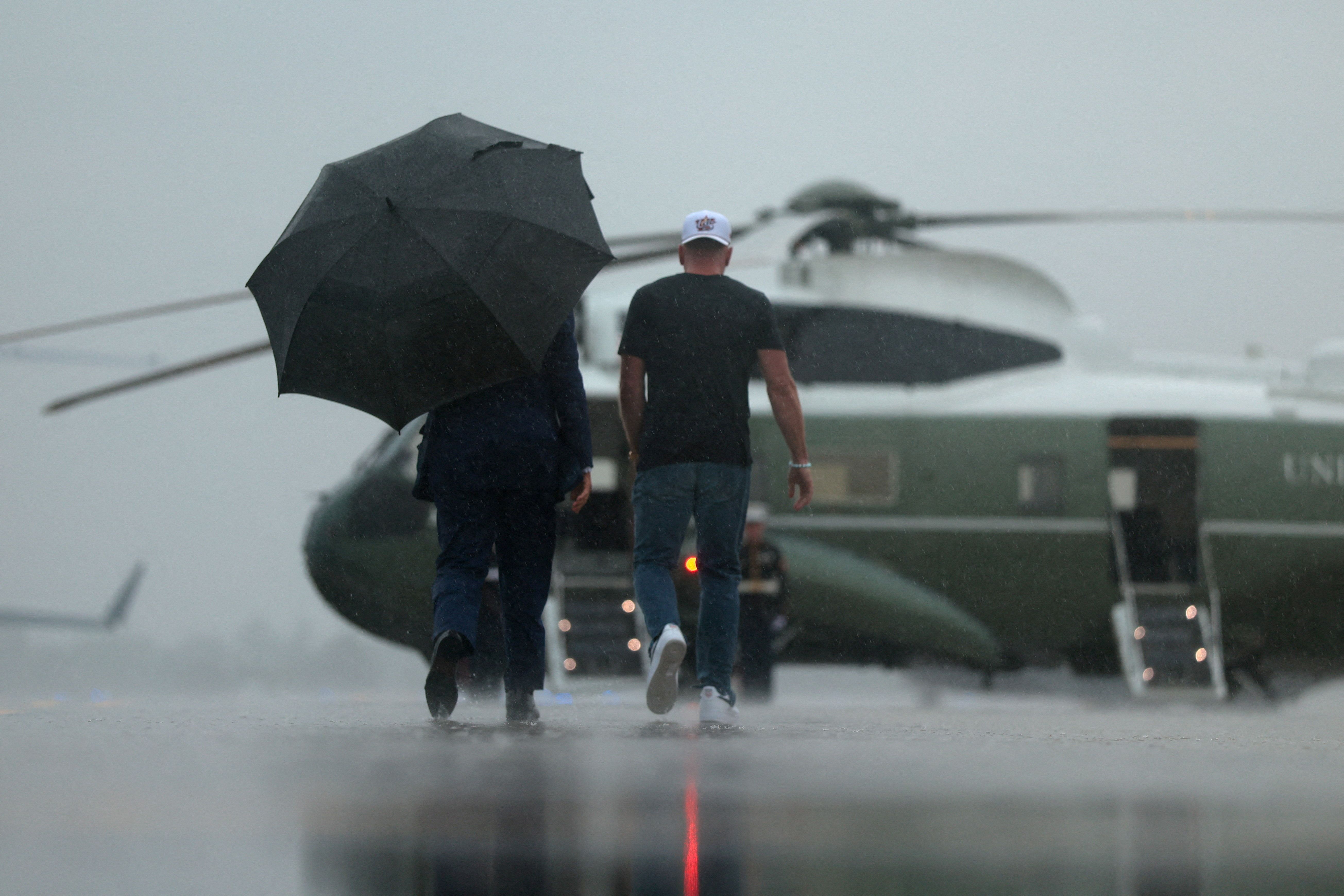 Trump and ESPN broadcaster Pat McAfee walk toward Marine One at Cleveland Hopkins International Airport.