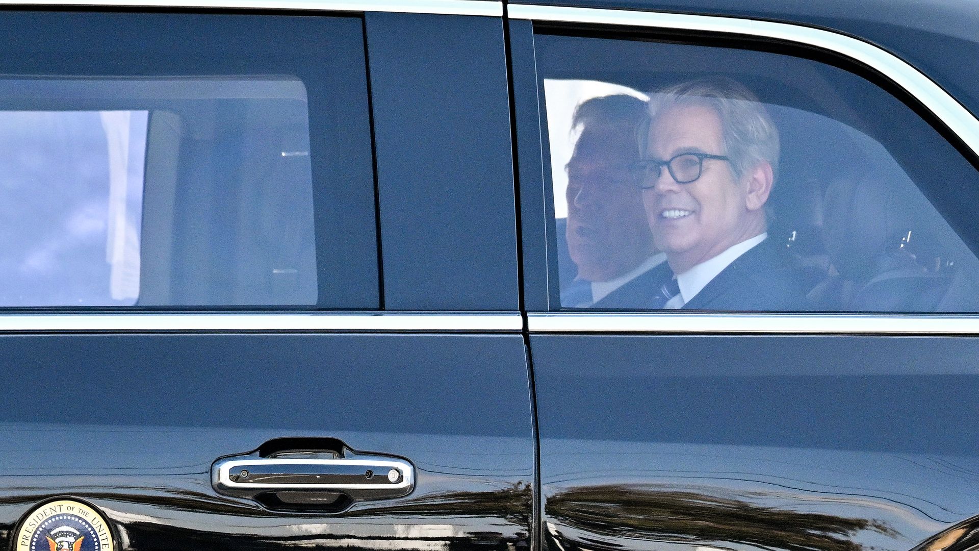 Treasury Secretary Scott Bessent and President Trump, seen through the window of a limo. 