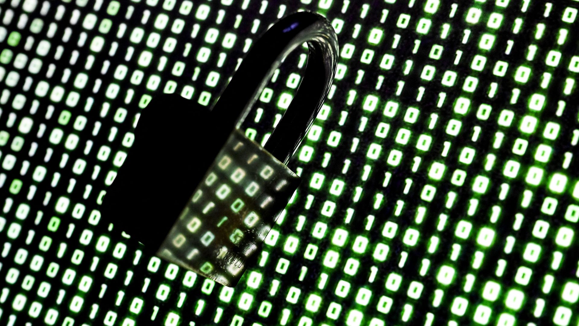 An illustration of a padlock in front of binary code displayed on a laptop screen.