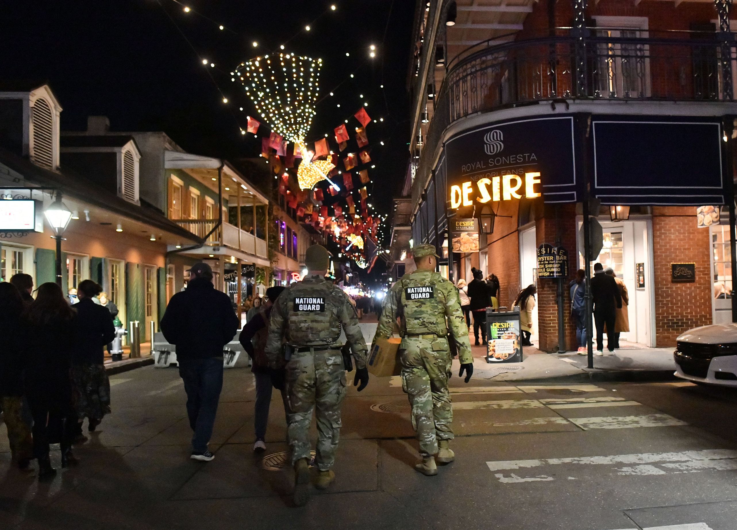 Two National Guardsmen are seen walking away from the camera toward the Royal Sonesta. 