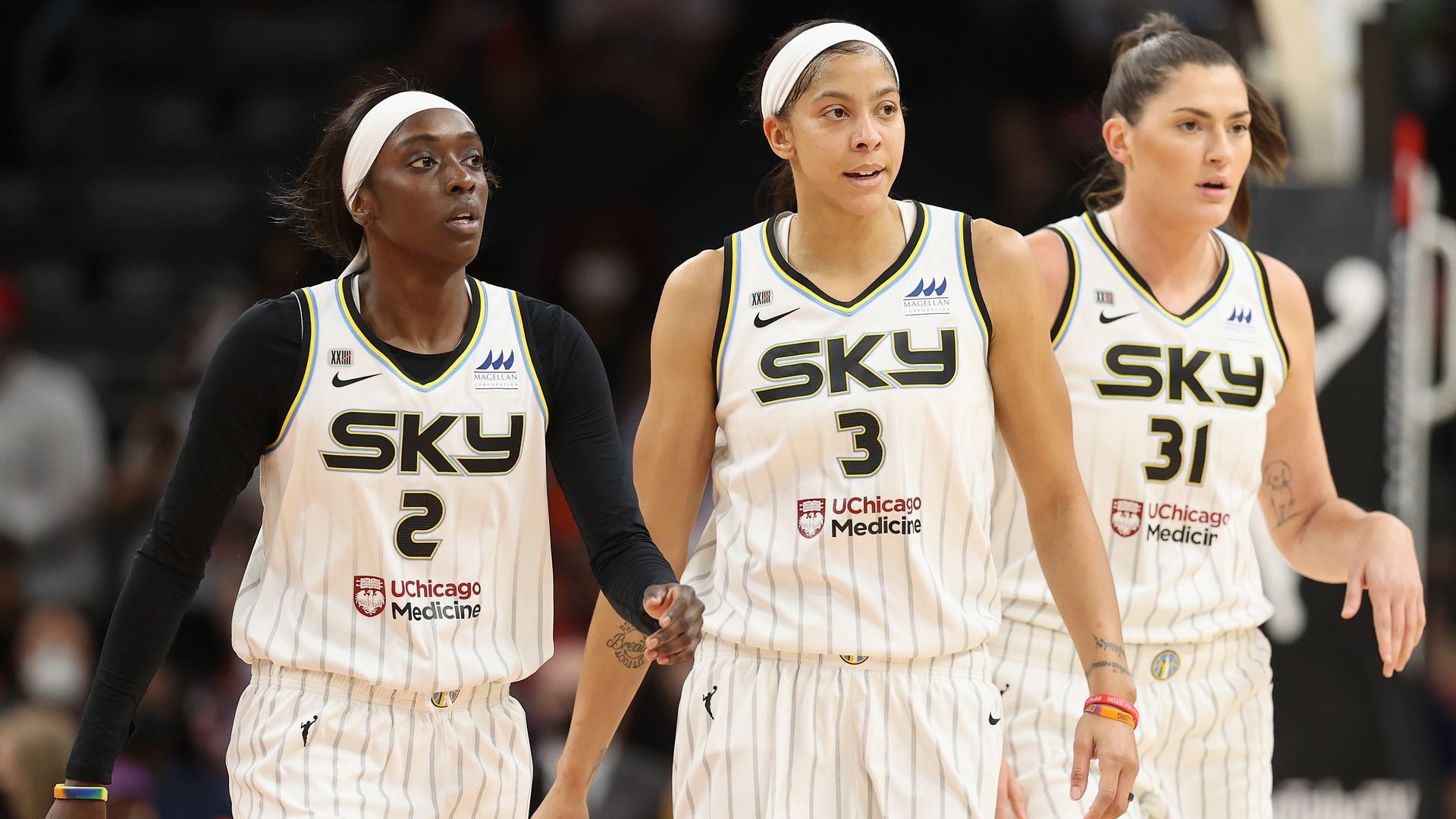 Basketball players walk off court.