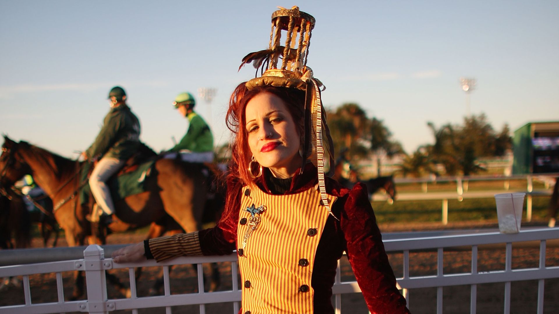 Photo shows a person with an extravagant hat at the Fair Grounds in New Orleans
