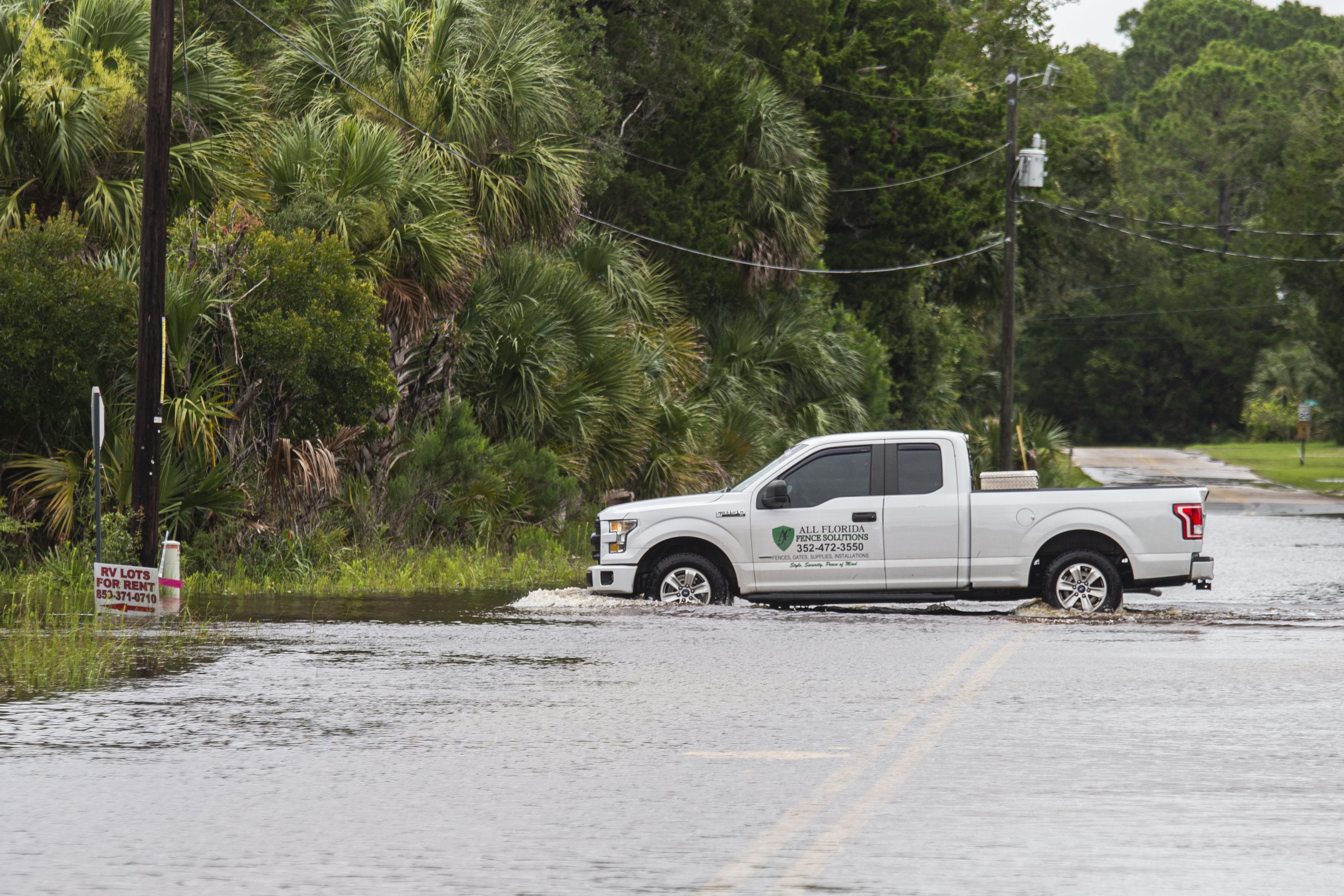 A truck drives through a flooded street after Tropical Storm Elsa made landfall nearby on July 7 in Steinhatchee, Florida.
