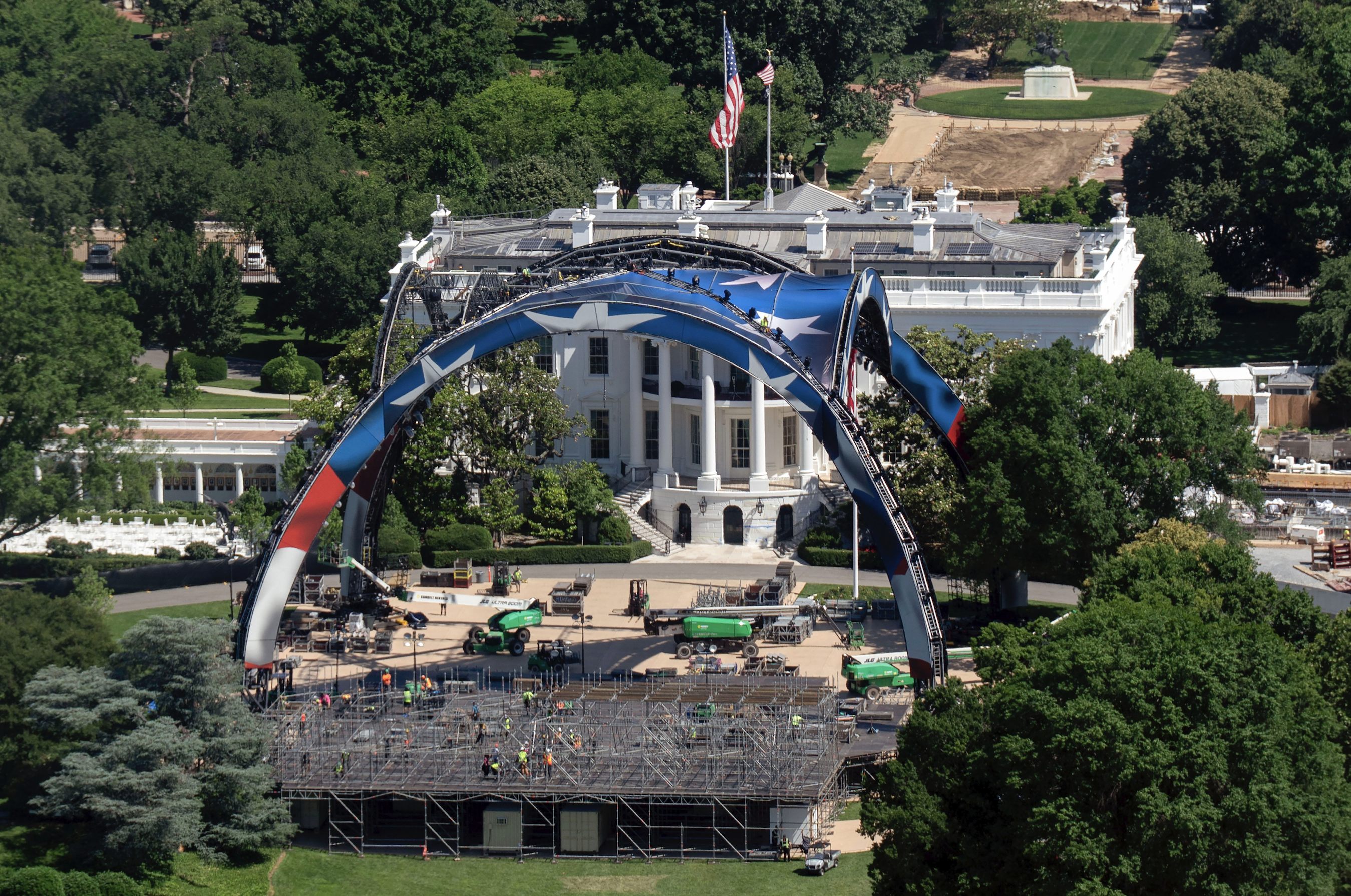 Workers build the cage for a UFC fight on the South Lawn in front of the White House, as seen from the Washington Monument.