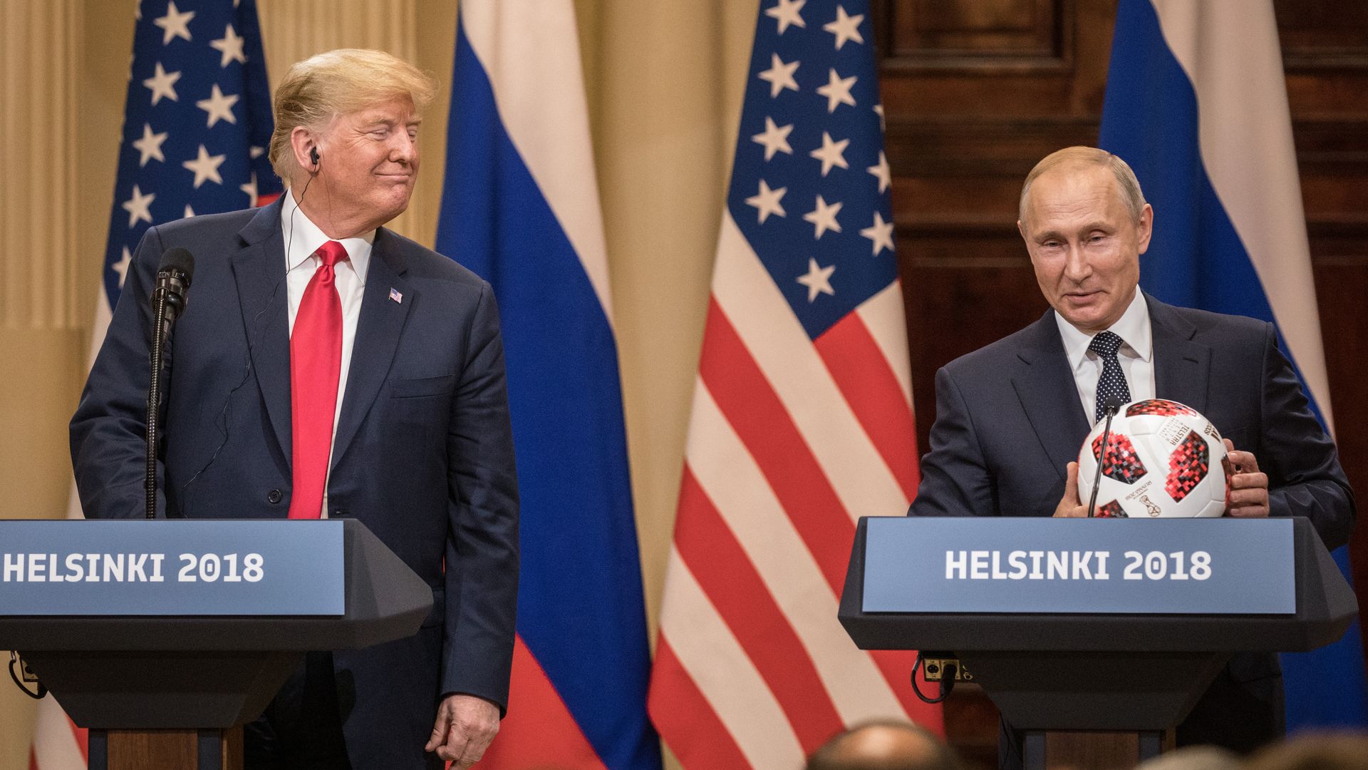 Russian President Vladimir Putin hands U.S. President Donald Trump a World Cup football during a joint press conference after their summit on July 16, 2018, in Helsinki.