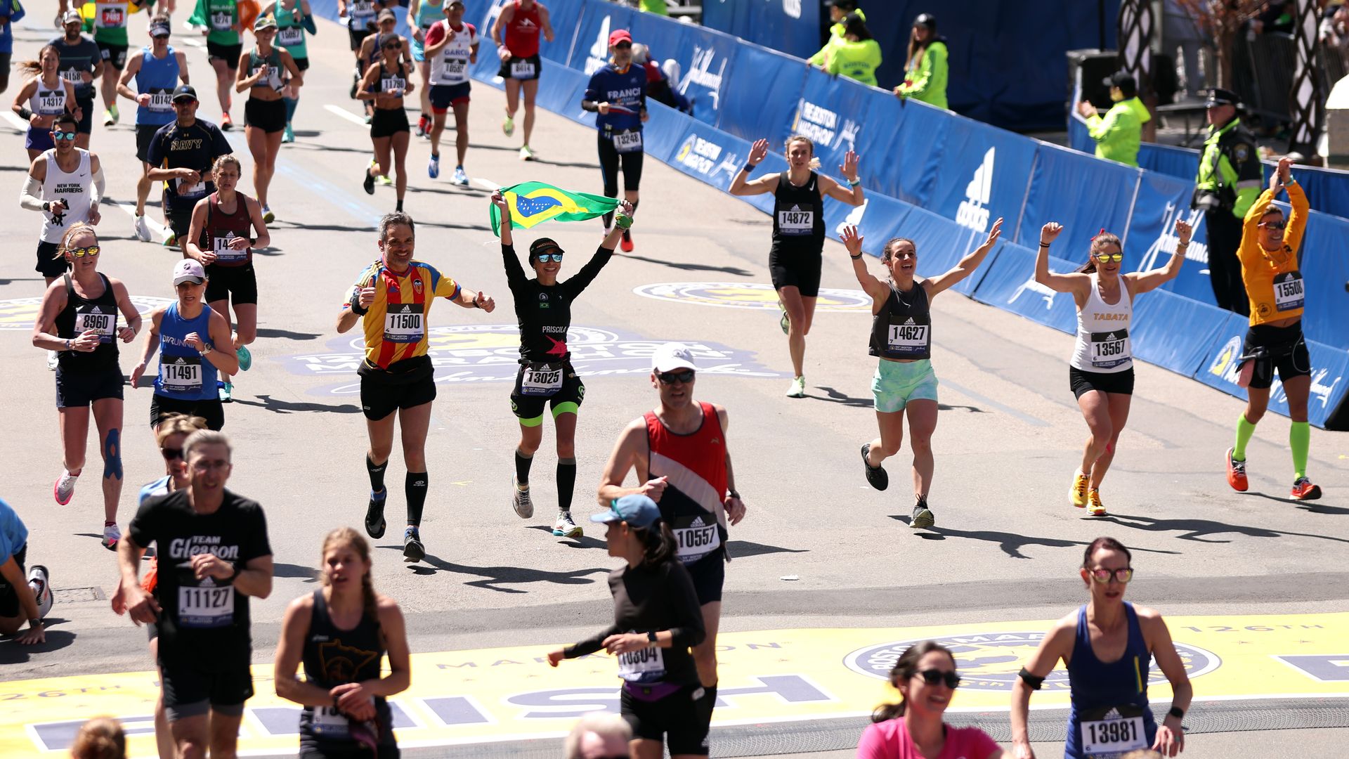 Runners cross the finish line during the 126th Boston Marathon on April 18, 2022 in Boston, Massachusetts.