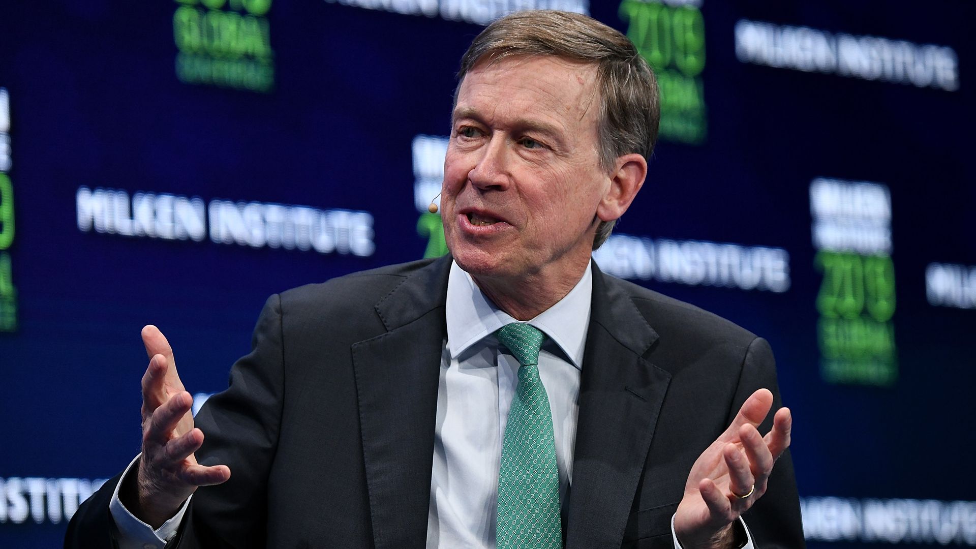 John Hickenlooper gestures during a panel discussion in California.