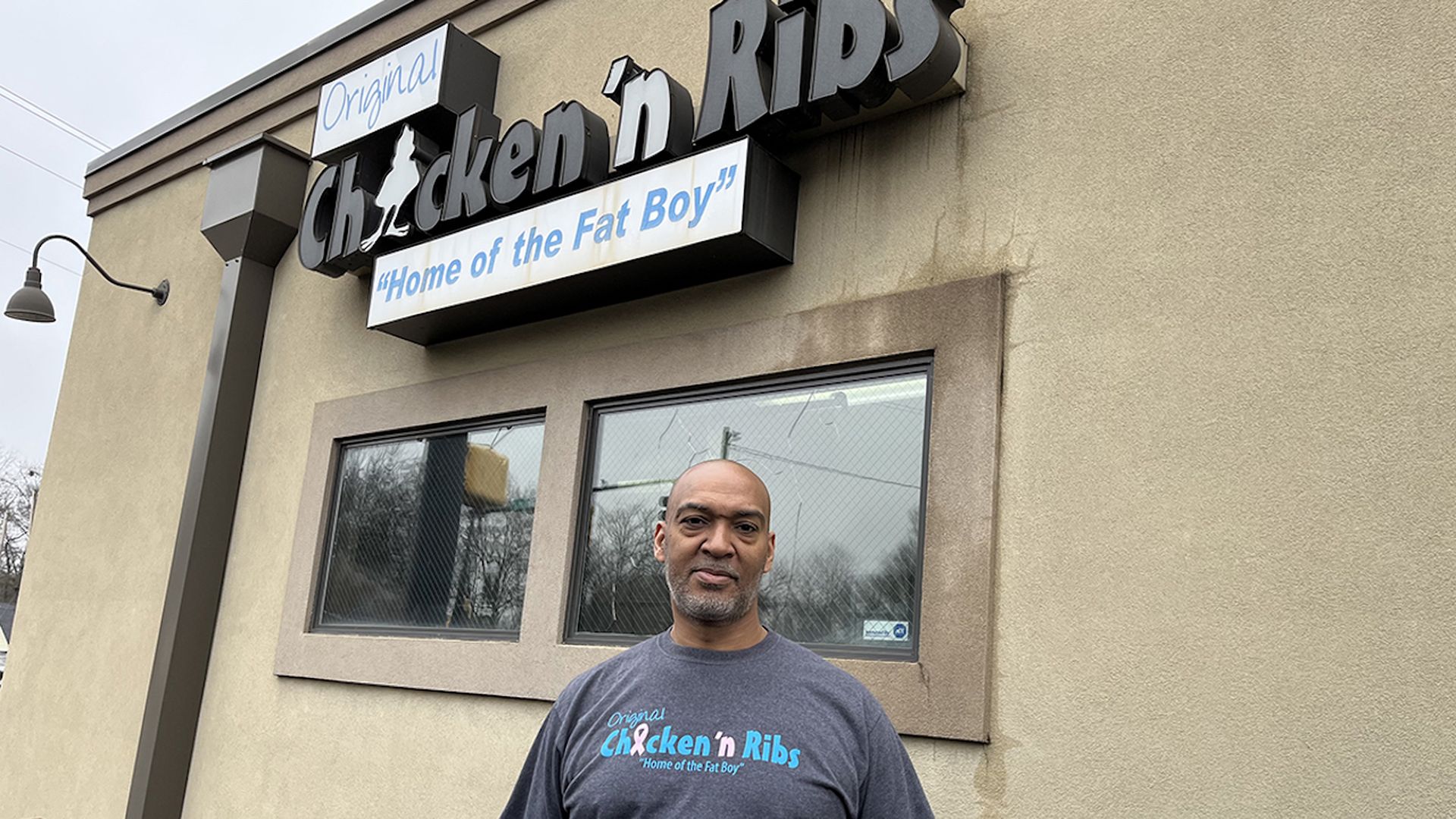 man standing outside of restaurant
