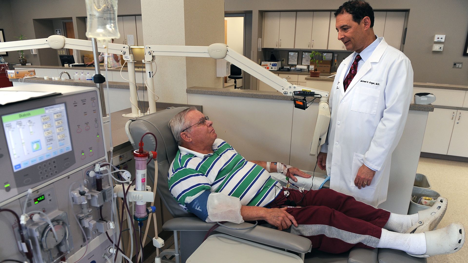 A doctor meets with a dialysis patient during treatment.