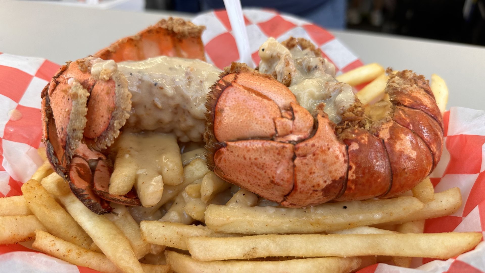 a tray with two lobster tails, fries and gravy