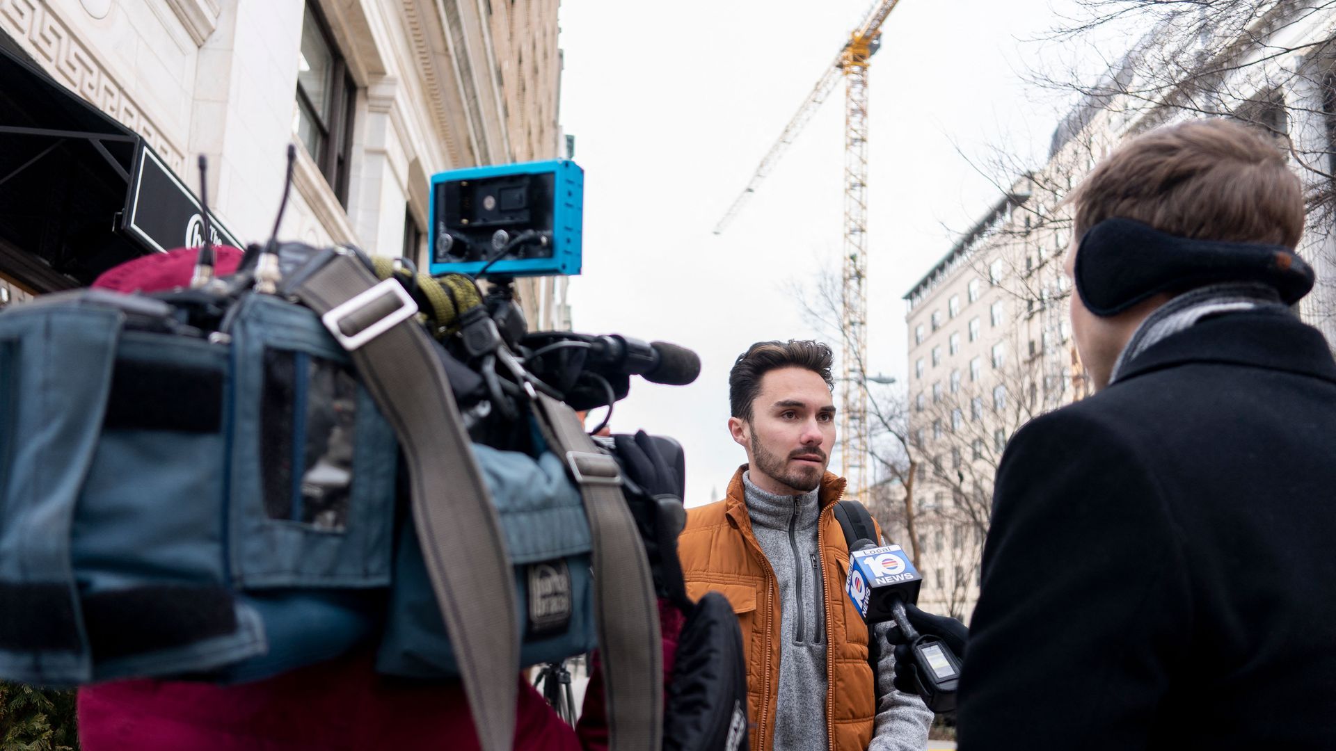 David Hogg speaks to a reporter holding a microphone