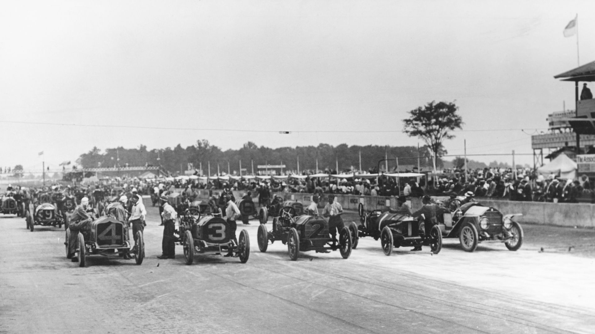 A black and white photo of cars at a starting line