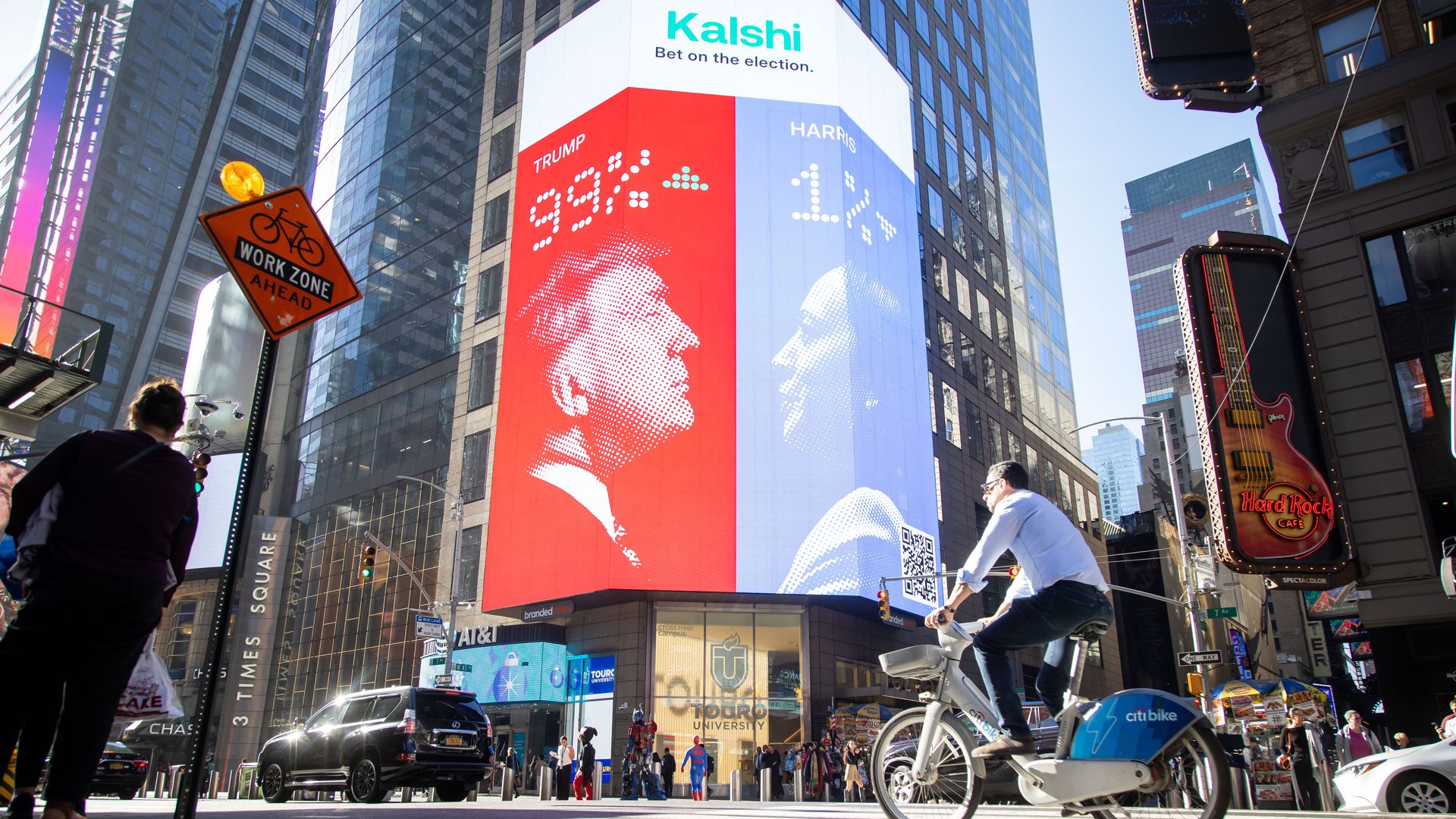 A Kalshi electronic billboard showing Trump and Harris facing each other, with their election odds.